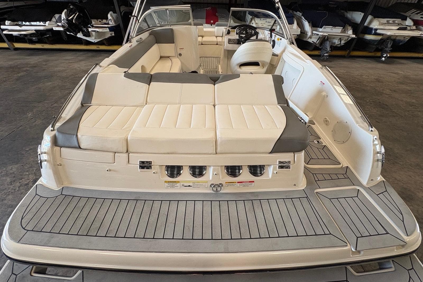 2014 Bayliner 215 Deck Boat with spacious seating and modern design in a showroom.