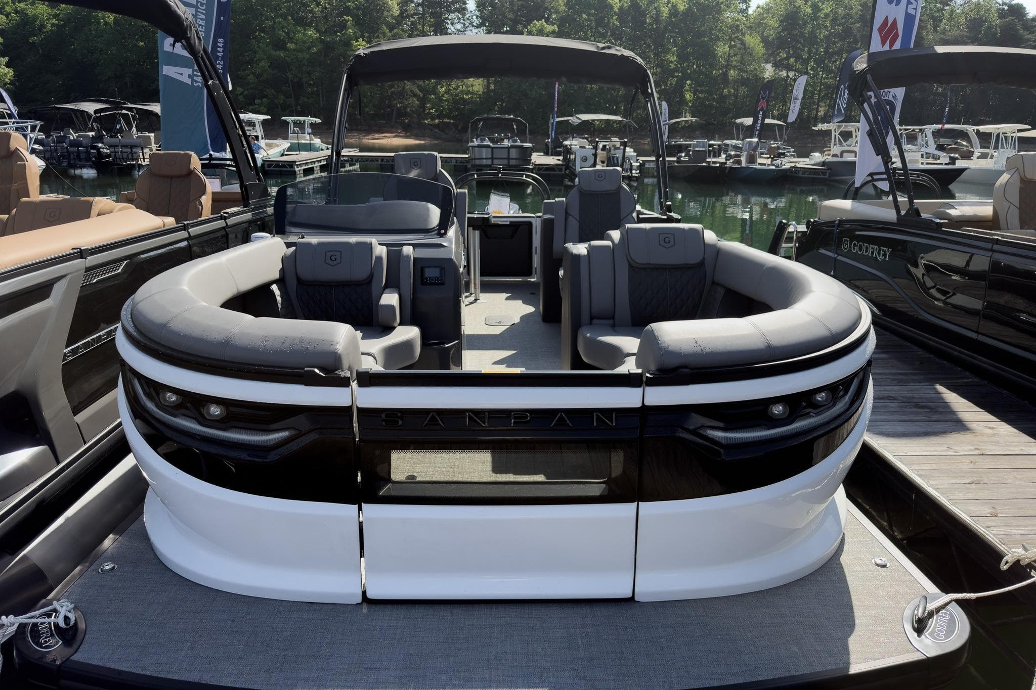 2026 Godfrey Sanpan 23' Split Bench Tritoon boat docked, showcasing luxurious seating and modern design.