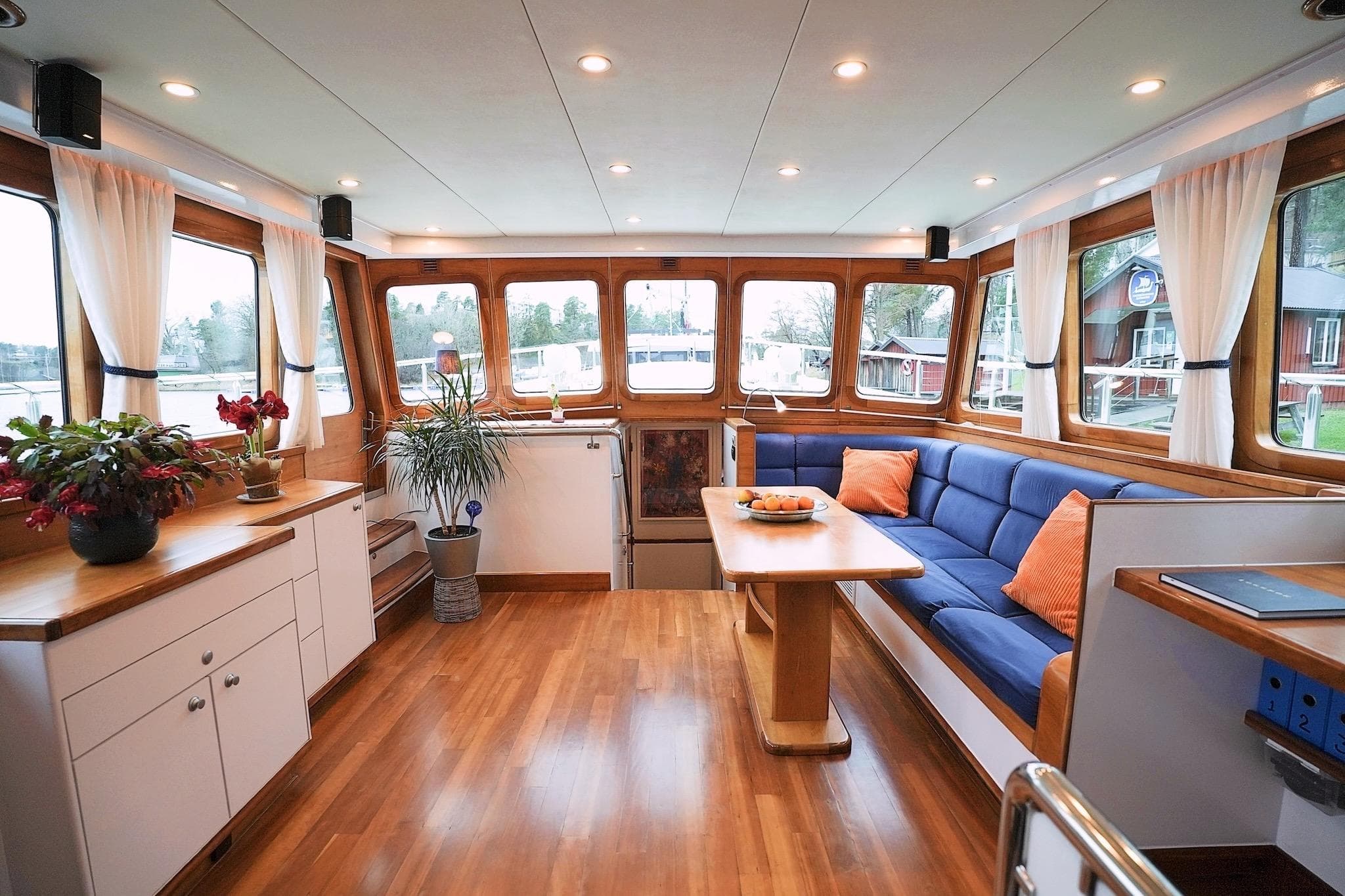 Luxurious Stentor 1800 yacht interior with wooden flooring, blue seating, and large windows, 2005 model.
