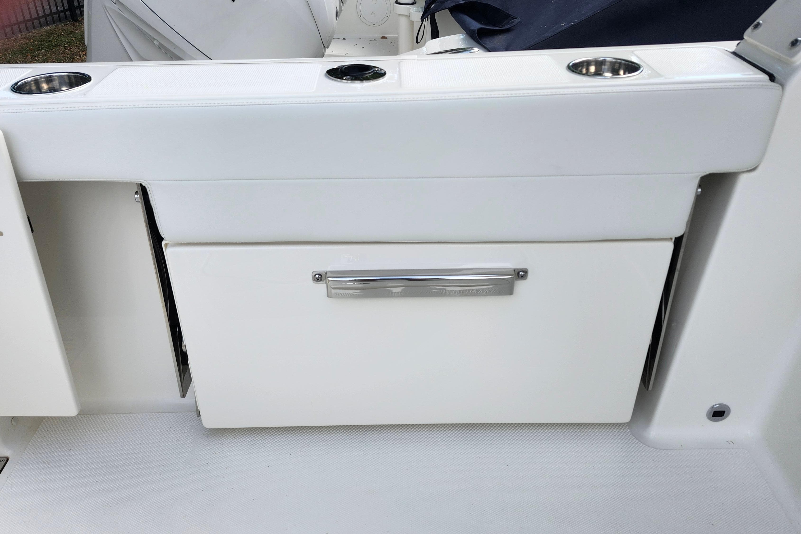 2026 Pursuit DC 286 Dual Console boat interior with storage compartment and cup holders.