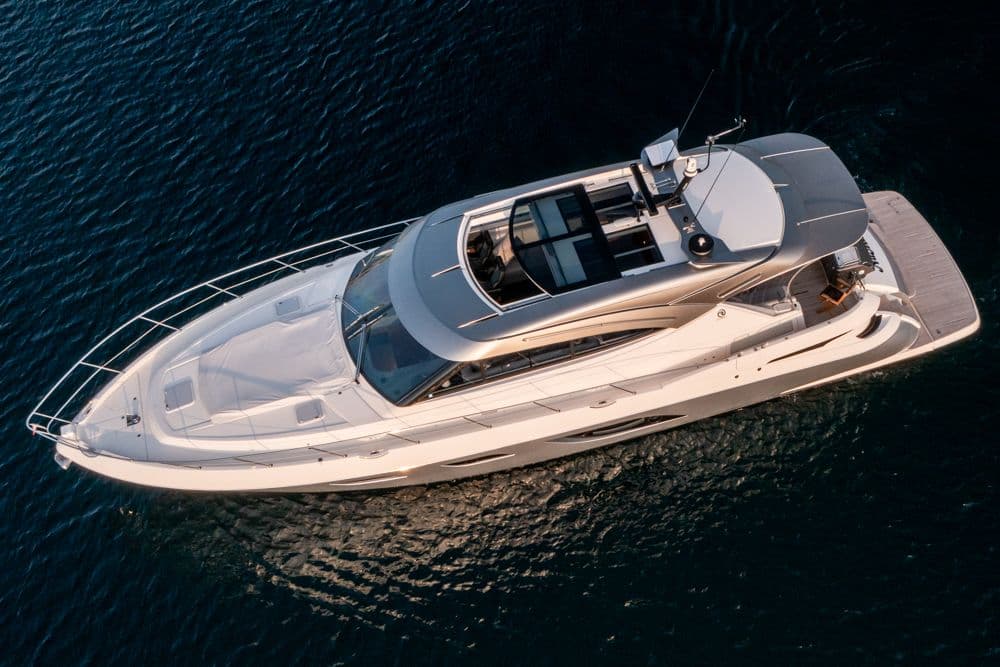2022 Riviera 6000 Sport Yacht Platinum cruising on open water, aerial view.