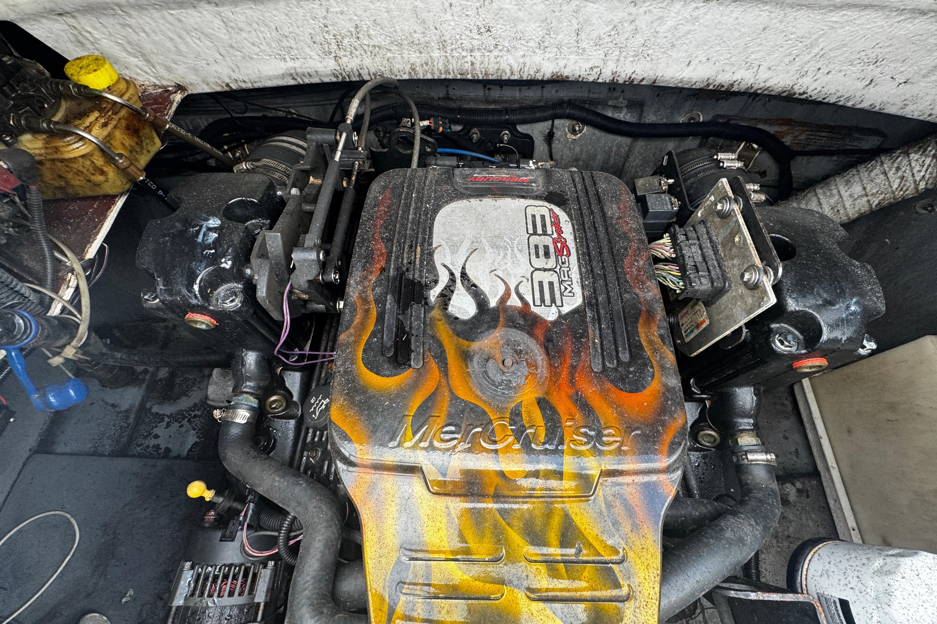 Engine of a 2008 Splendor 240 Sunstar boat with flame design on cover.