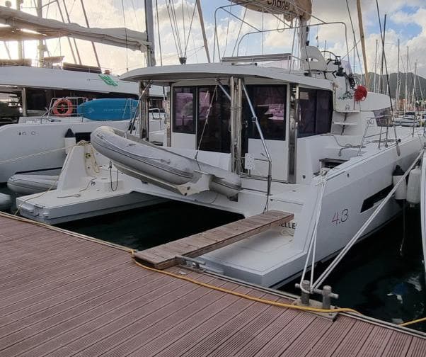 2015 Bali 4.3 catamaran docked at marina with inflatable dinghy.