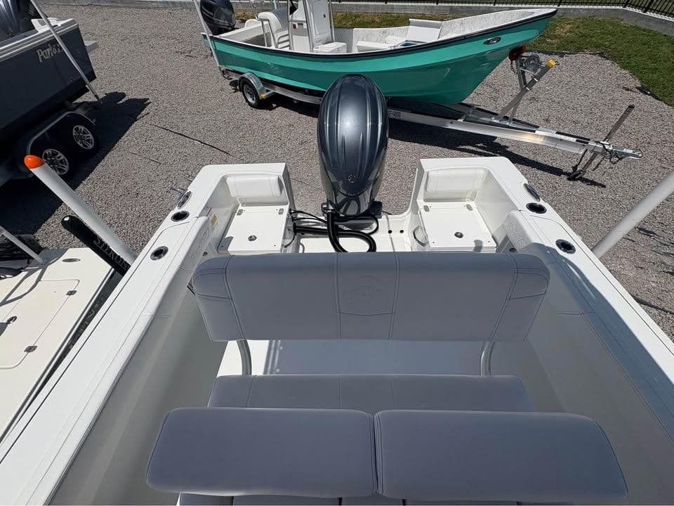 2026 Parker 210 COASTAL boat with outboard motor, parked on gravel with another boat nearby.