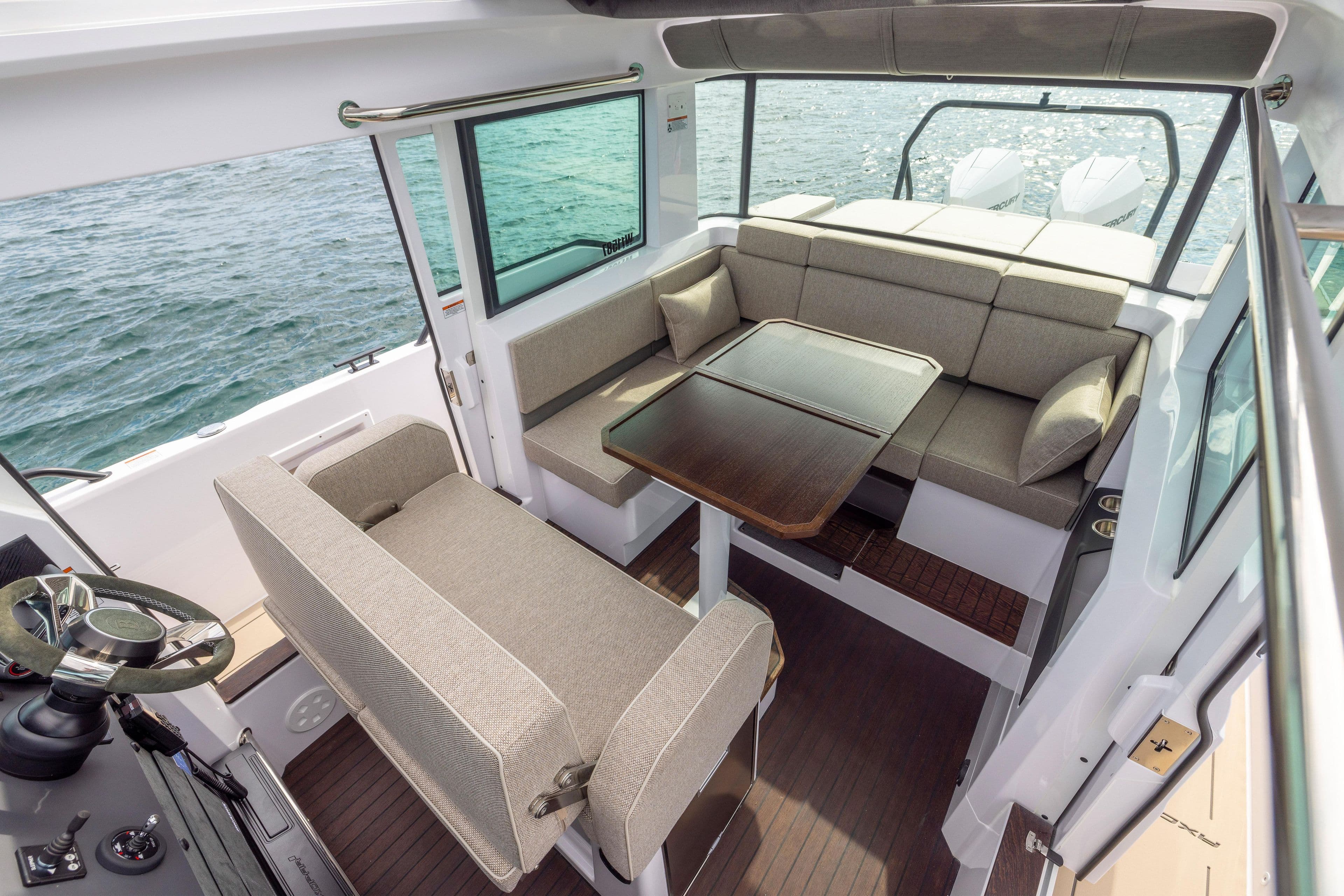 2024 Axopar 37 XC interior with seating, table, and ocean view.