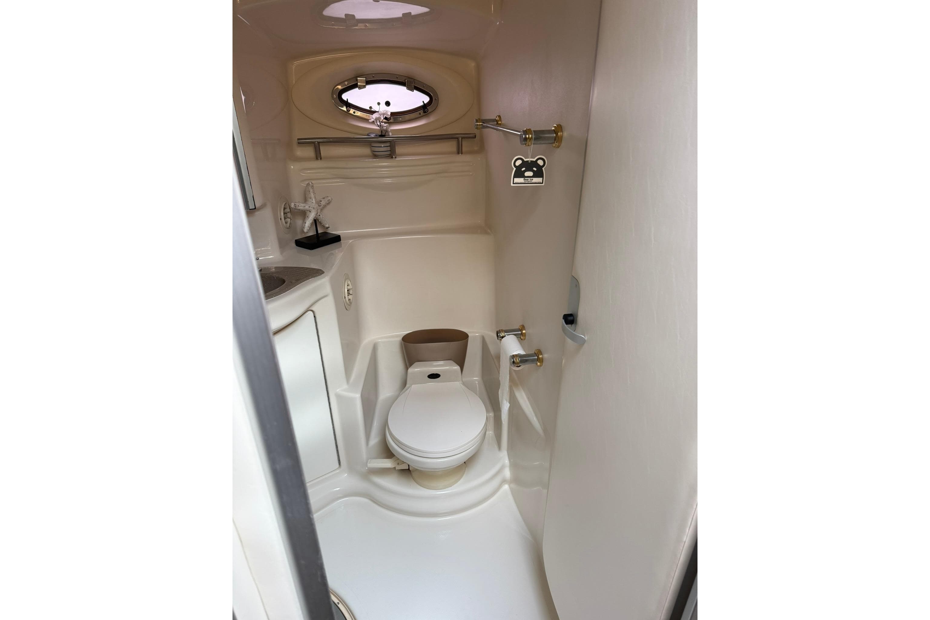 1999 Maxum 4600 SCB yacht bathroom with toilet, sink, and porthole window.