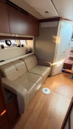 Interior of 2014 Sea Ray 410 Sundancer yacht with beige leather seating and wooden flooring.