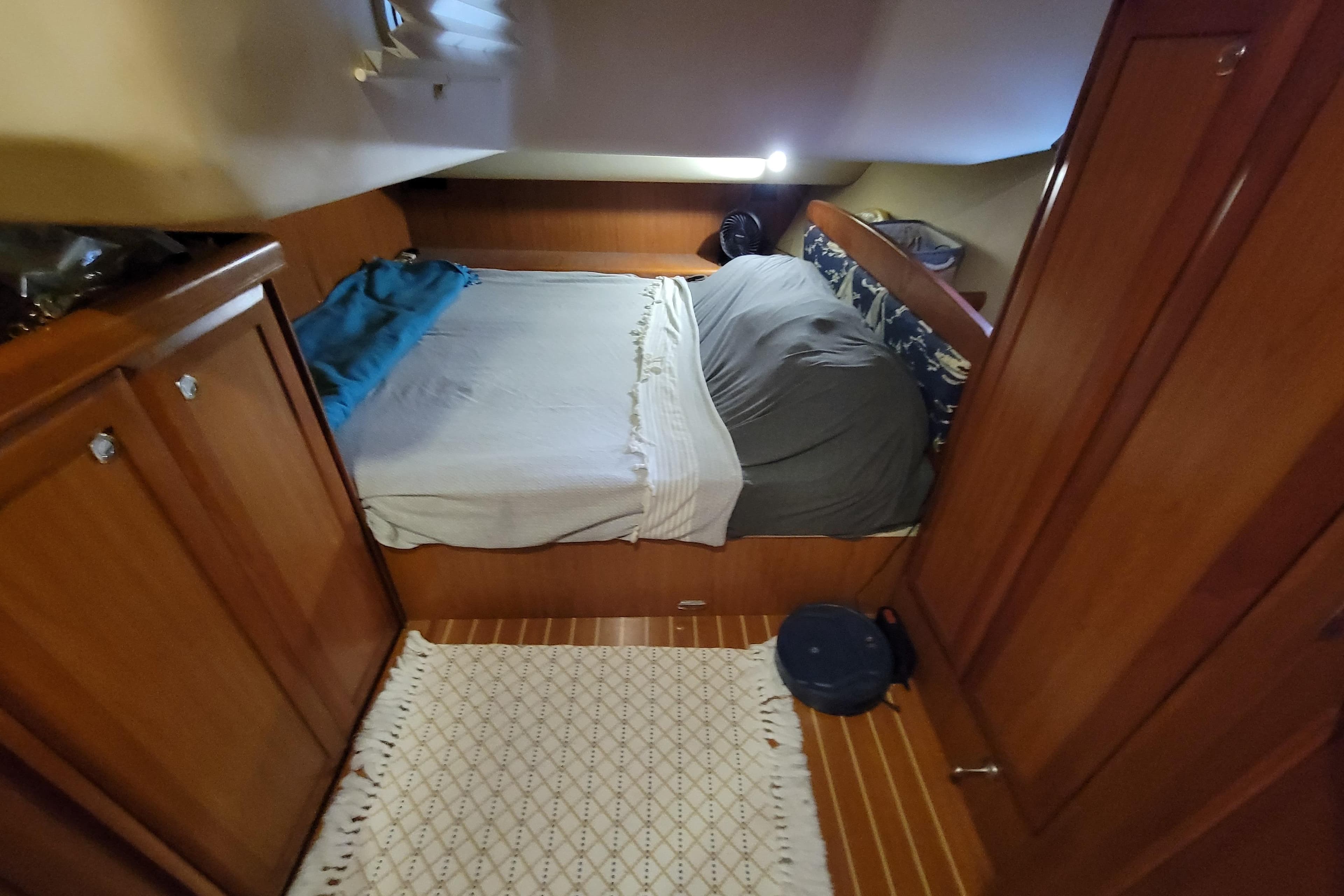 Cozy cabin interior of 2009 Hunter 49 yacht with wooden furnishings and bed.