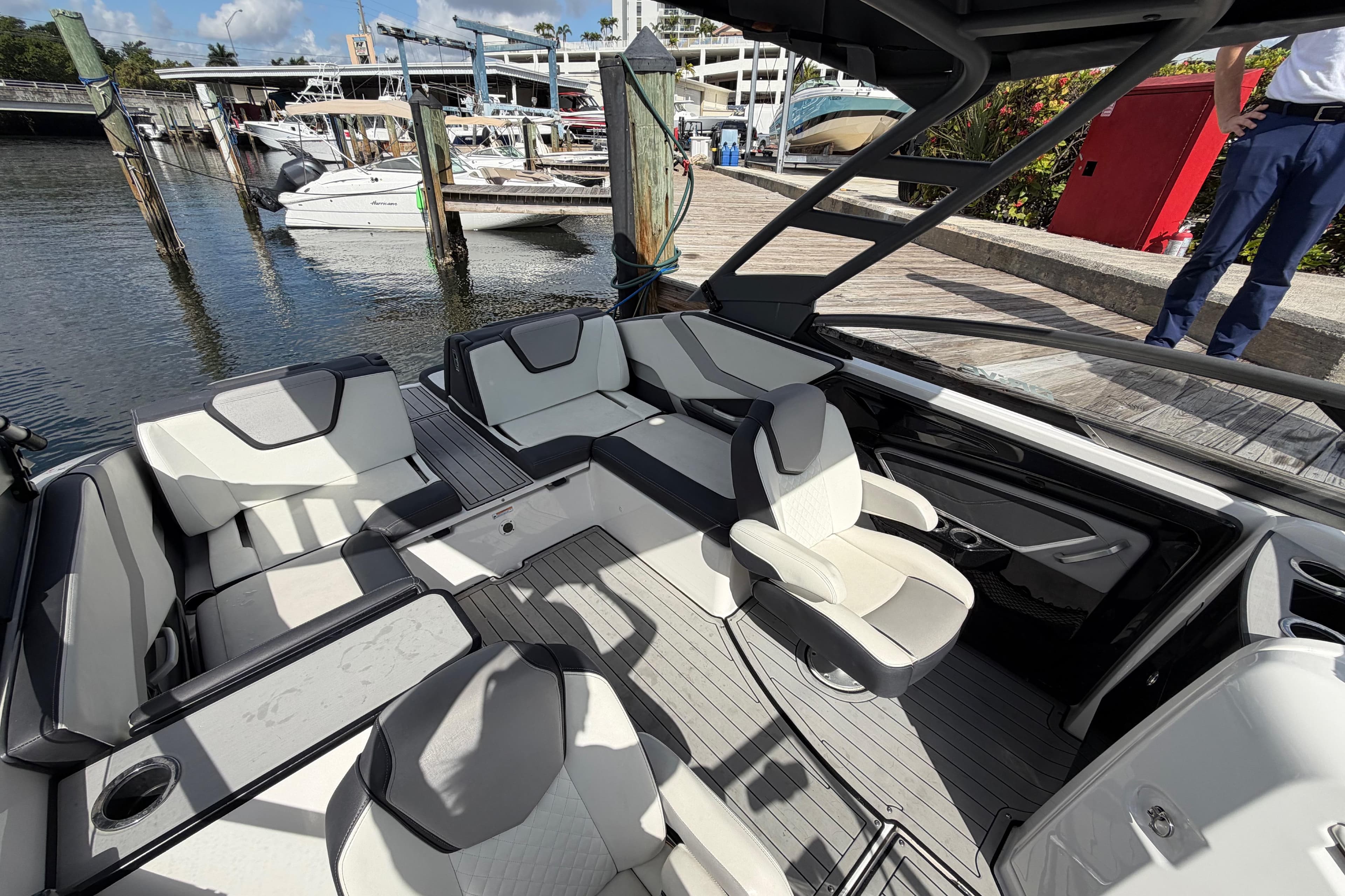 2022 Yamaha Boats 252SD interior with luxurious seating at a marina dock.