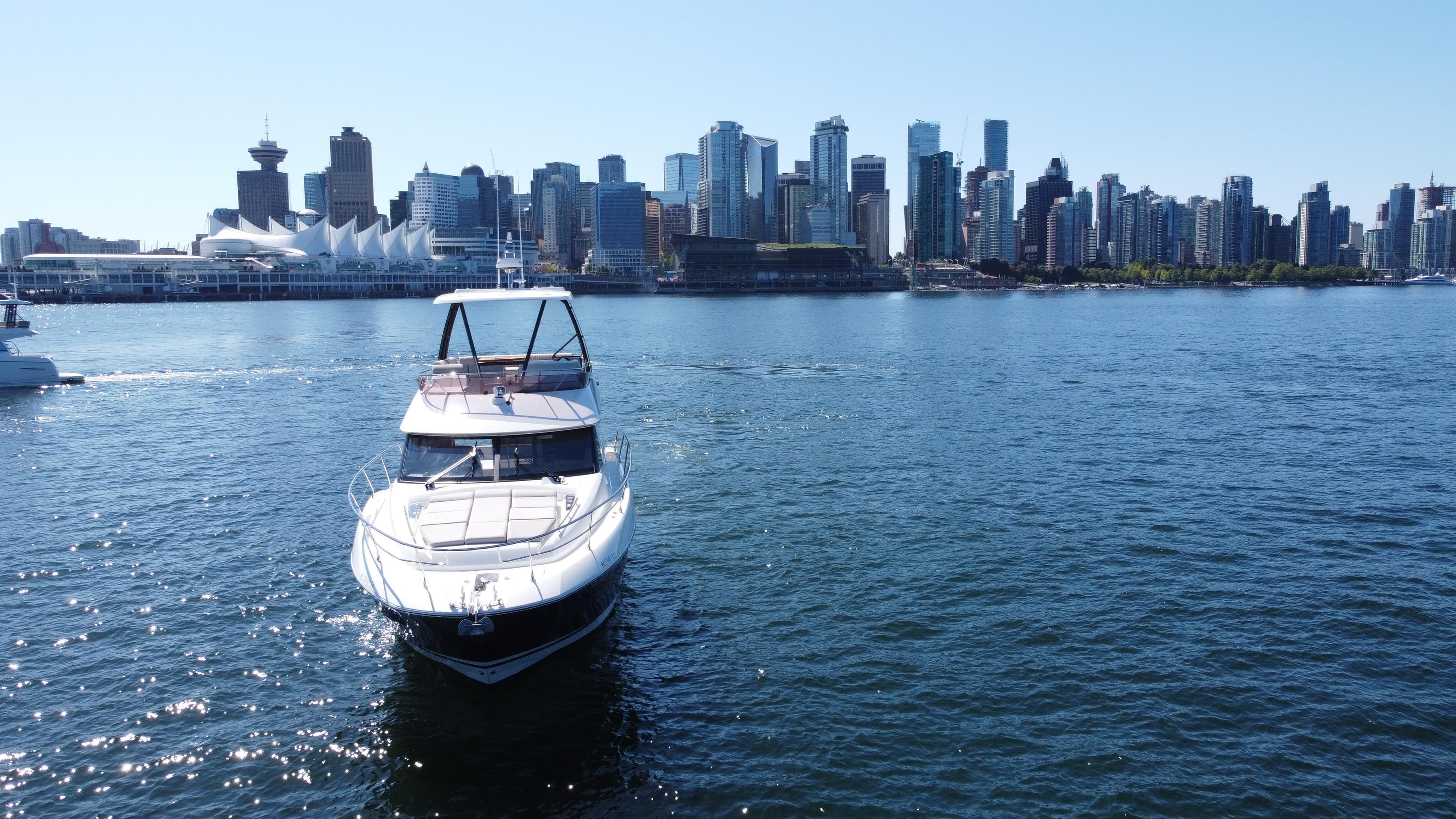 2022 Prestige 460 yacht on water with city skyline in background.