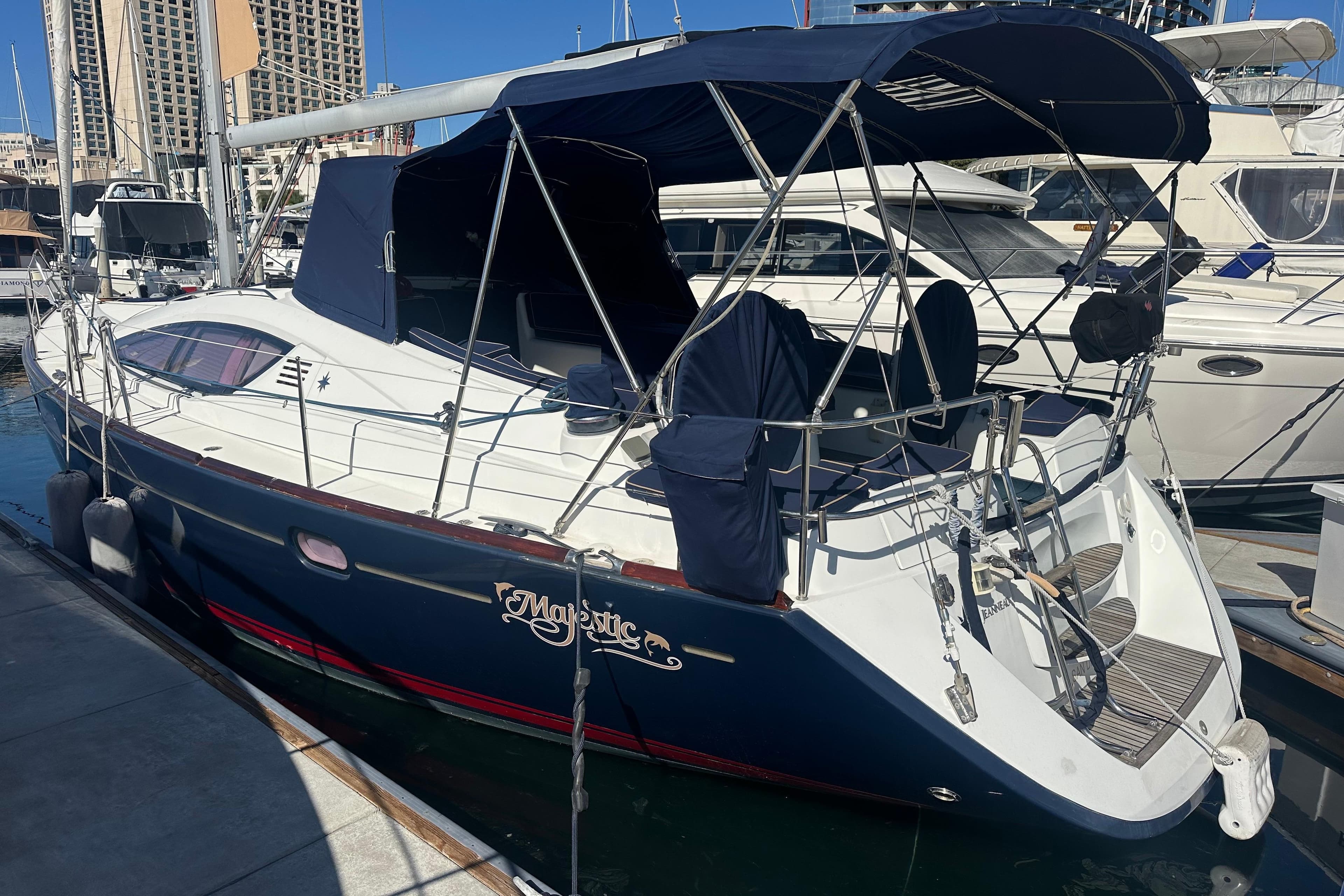 2008 Jeanneau Sun Odyssey 45 DS sailboat docked in marina, featuring blue canopy.