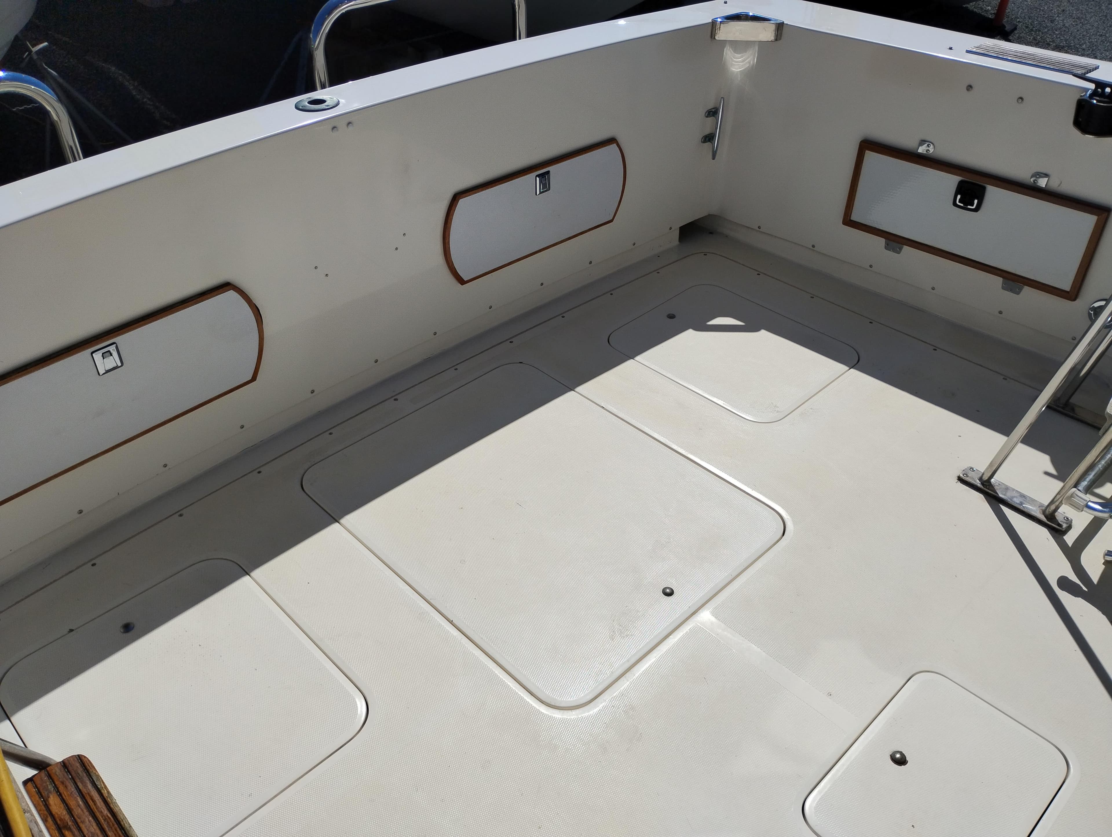 1978 Bertram 33 Convertible boat deck with storage compartments and clean white surface.
