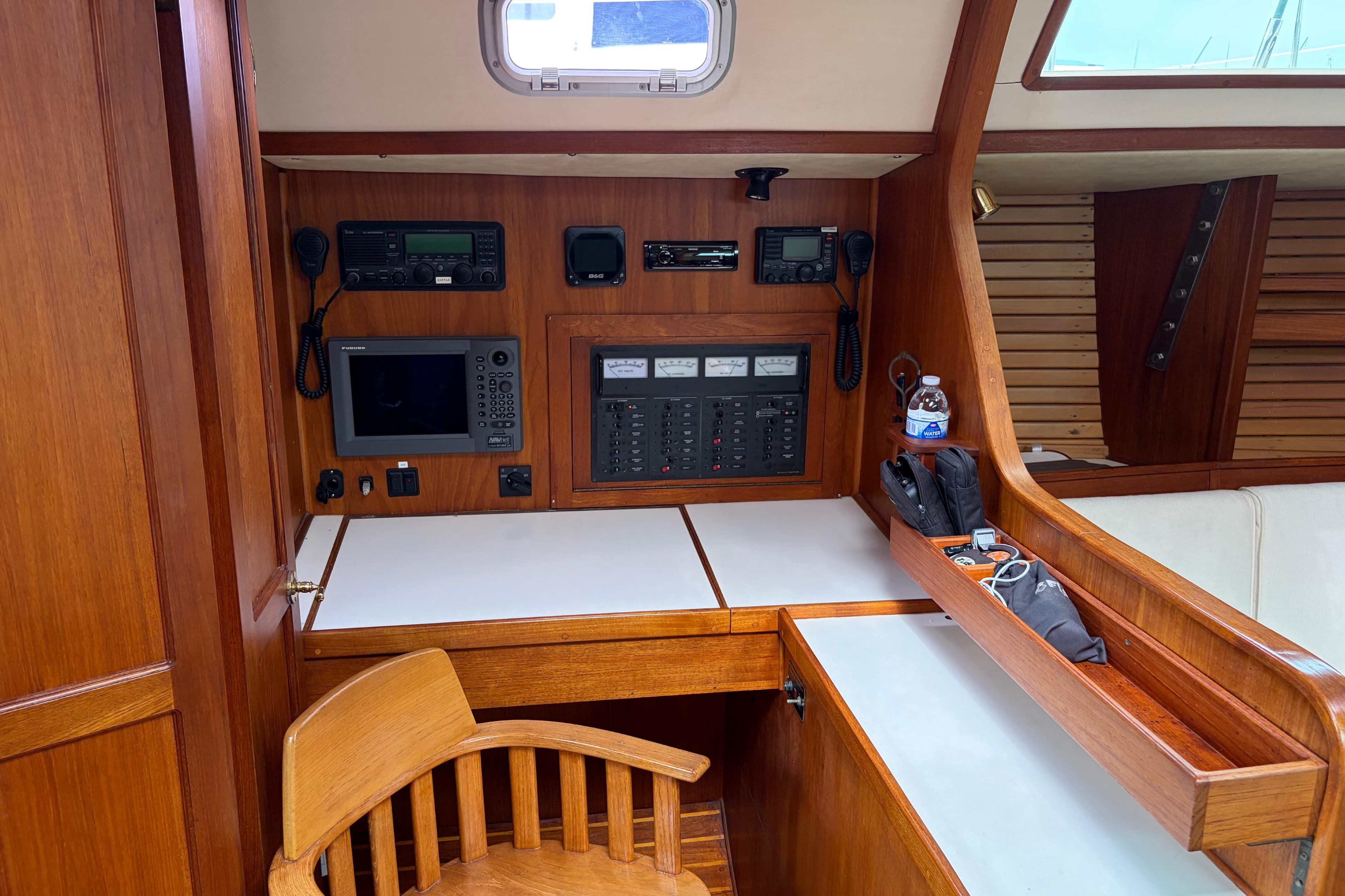 Navigation station inside a 1986 Nordic 44 sailboat with wooden interior and control panels.