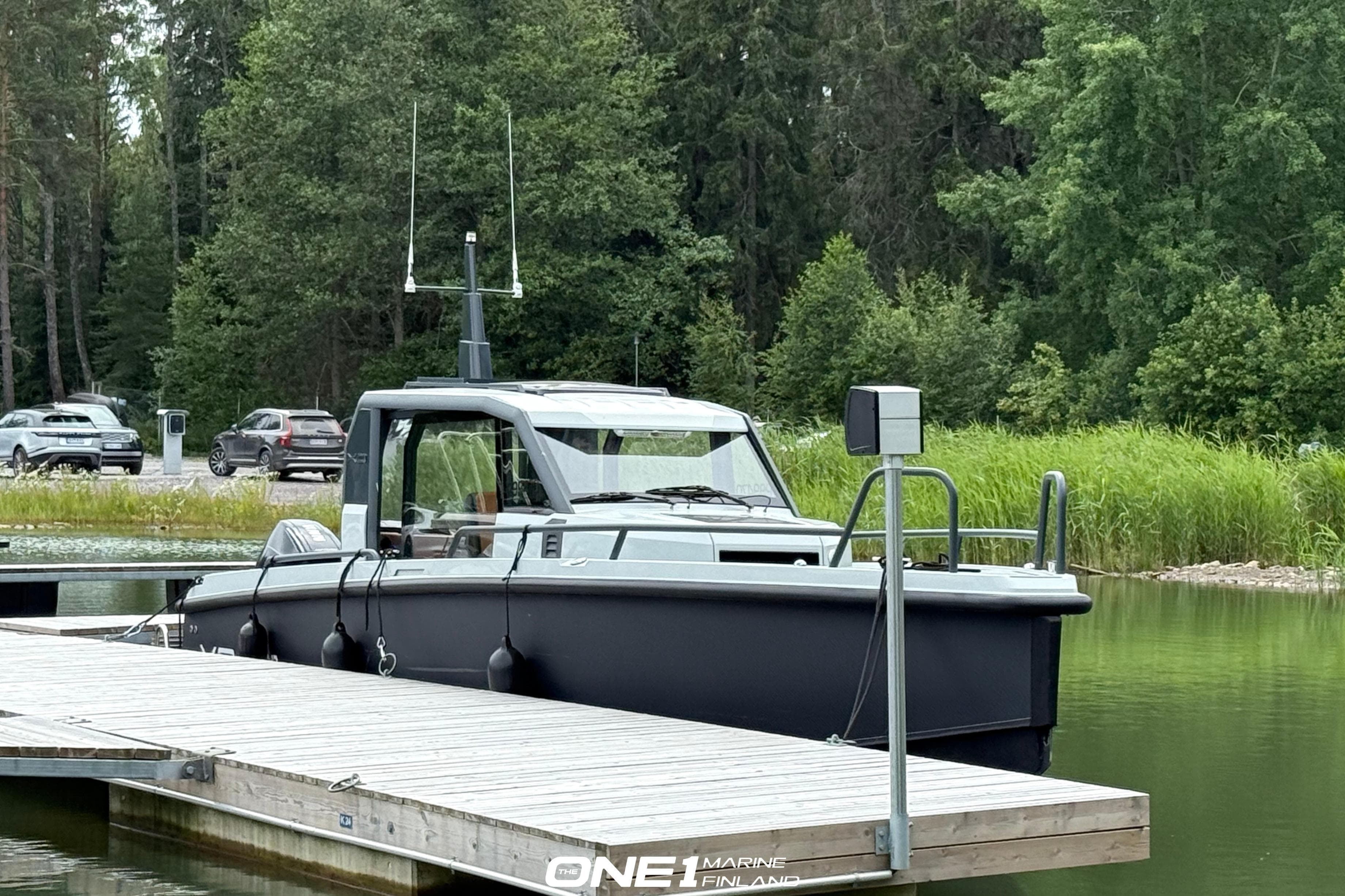 2022 XO DFNDR 9 boat docked by a lush, green lakeside.