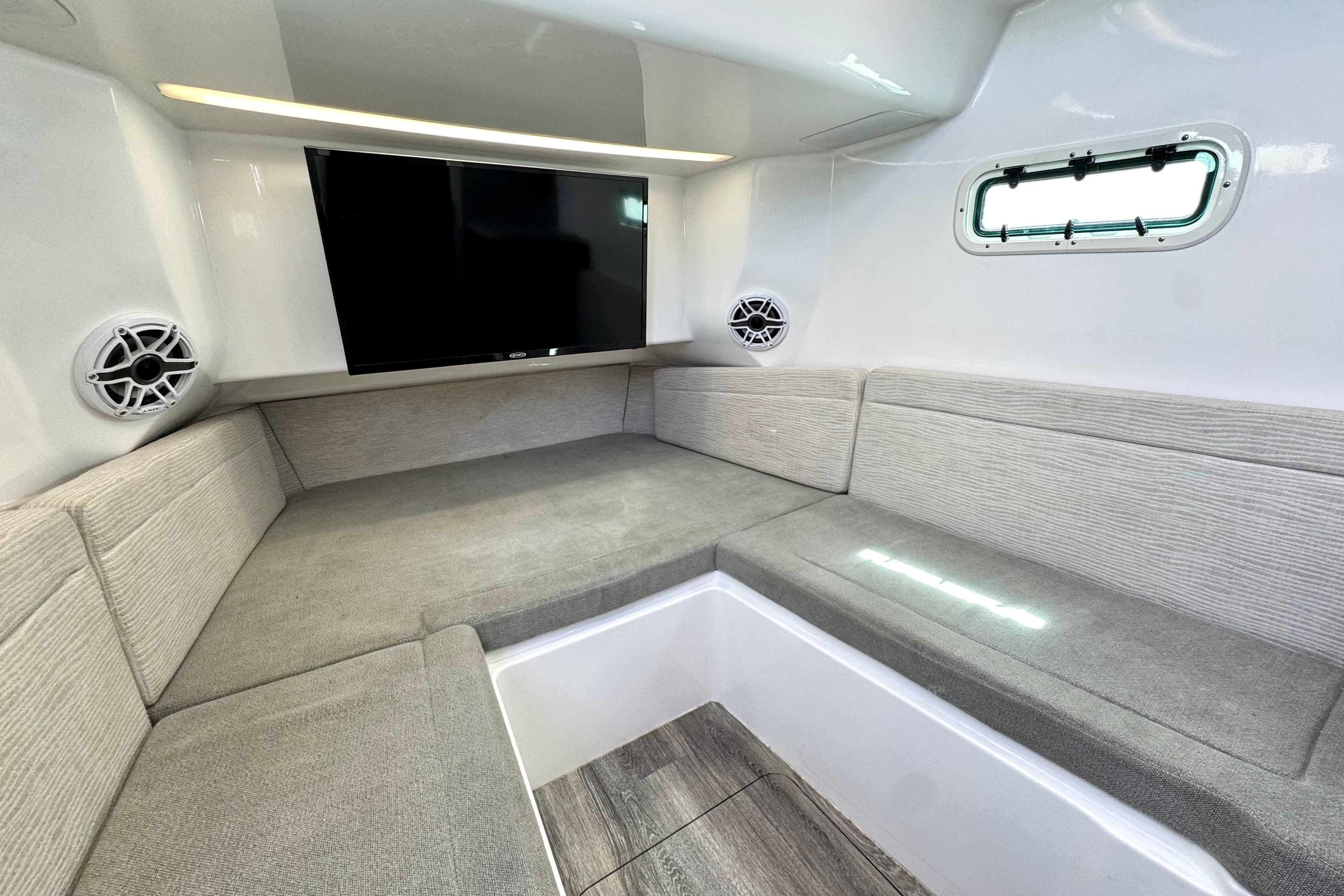 Luxurious interior of 2023 Everglades 395 Center Console boat with seating and TV.