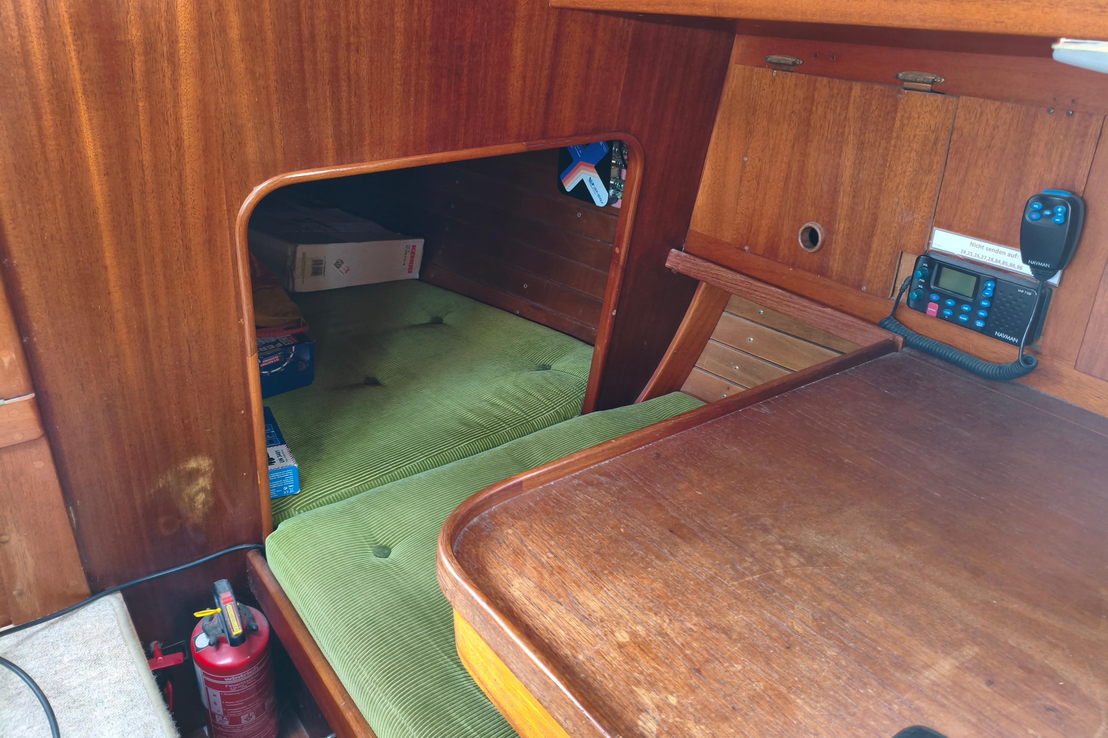 Interior of 1981 Vindo 50S sailboat with green cushions and navigation equipment.