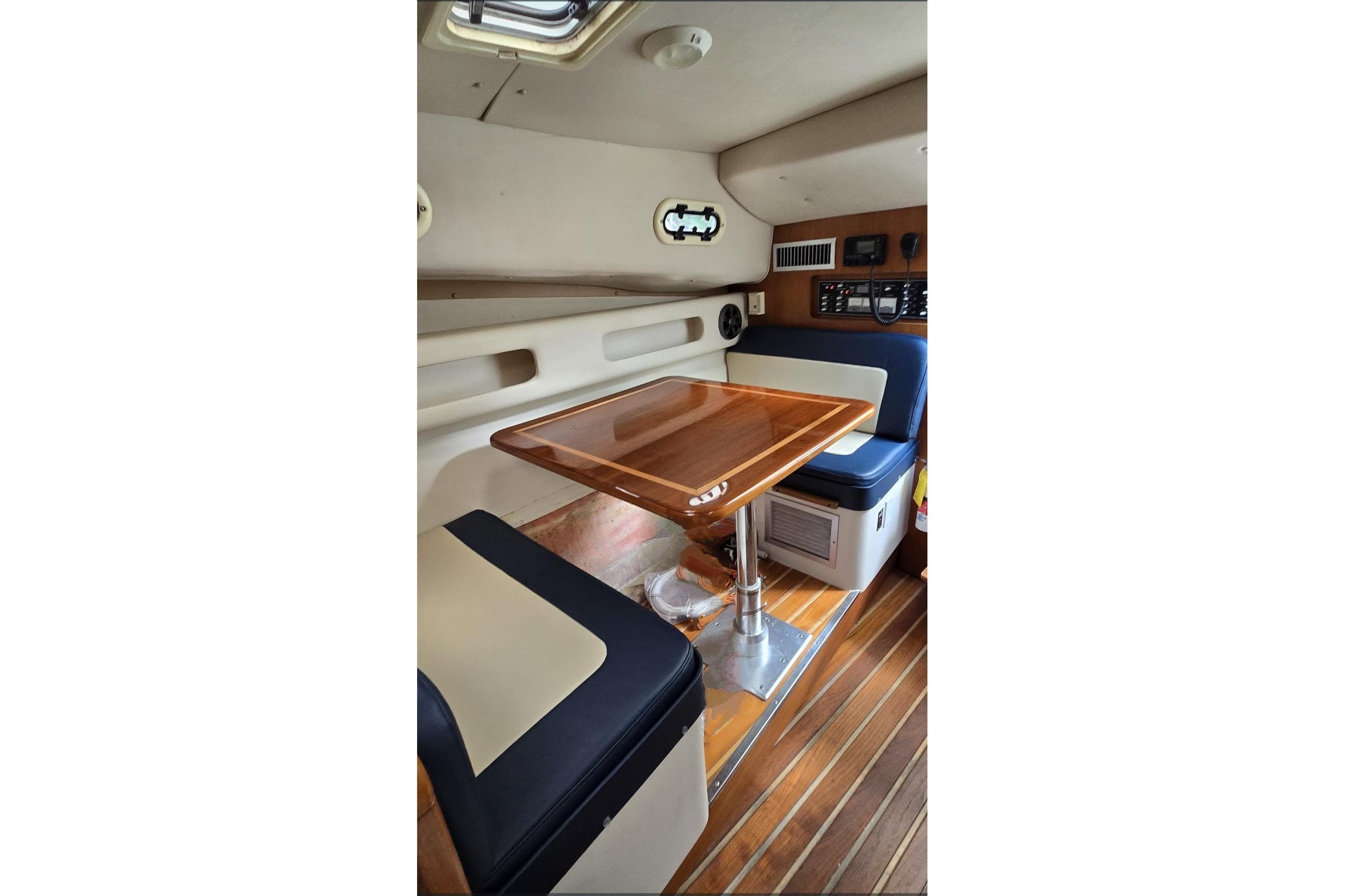Interior of 2000 Pursuit 3000 Express boat with wooden table and seating.