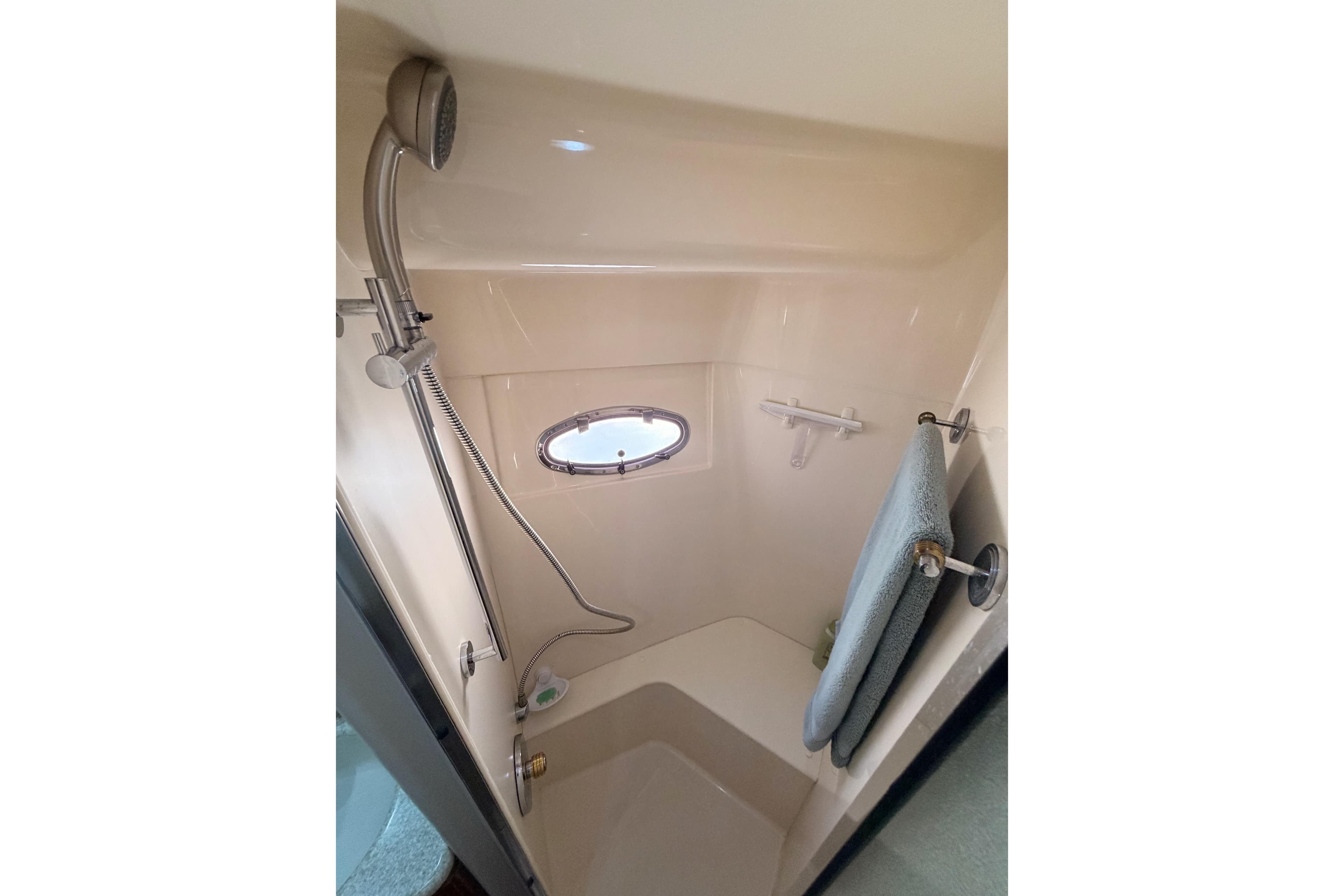 Shower area in 1999 Carver 530 Voyager Pilothouse with porthole and towel rack.