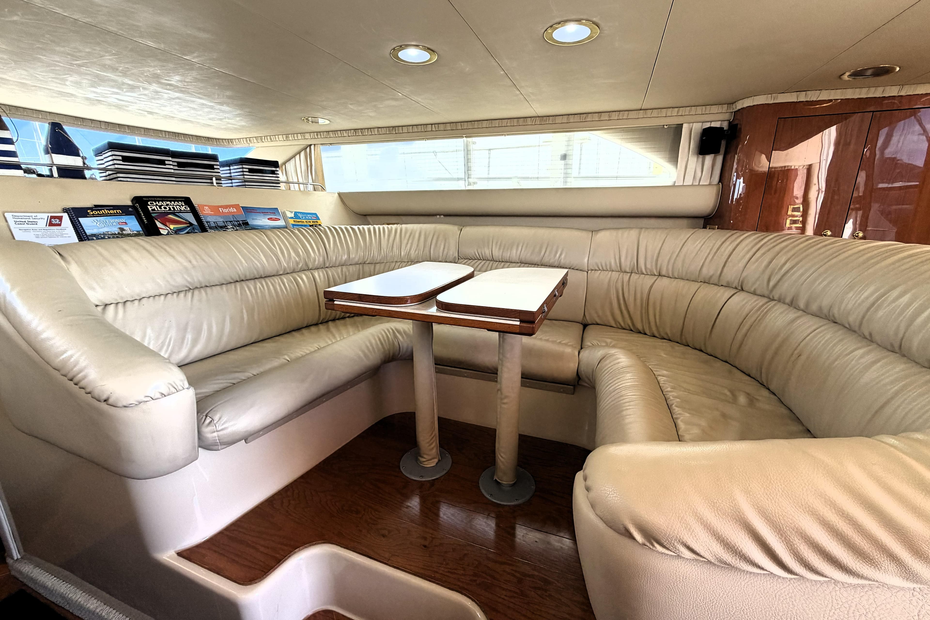 Luxurious interior of 2000 Sea Ray 450 Express Bridge with plush seating and wooden table.