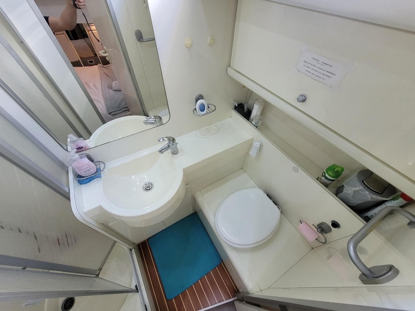 Bathroom interior of 1992 Guy Couach 1602 yacht, featuring sink, toilet, and storage.