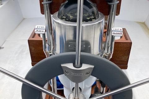 Steering wheel and compass of a 1988 Catalina 34 sailboat cockpit.