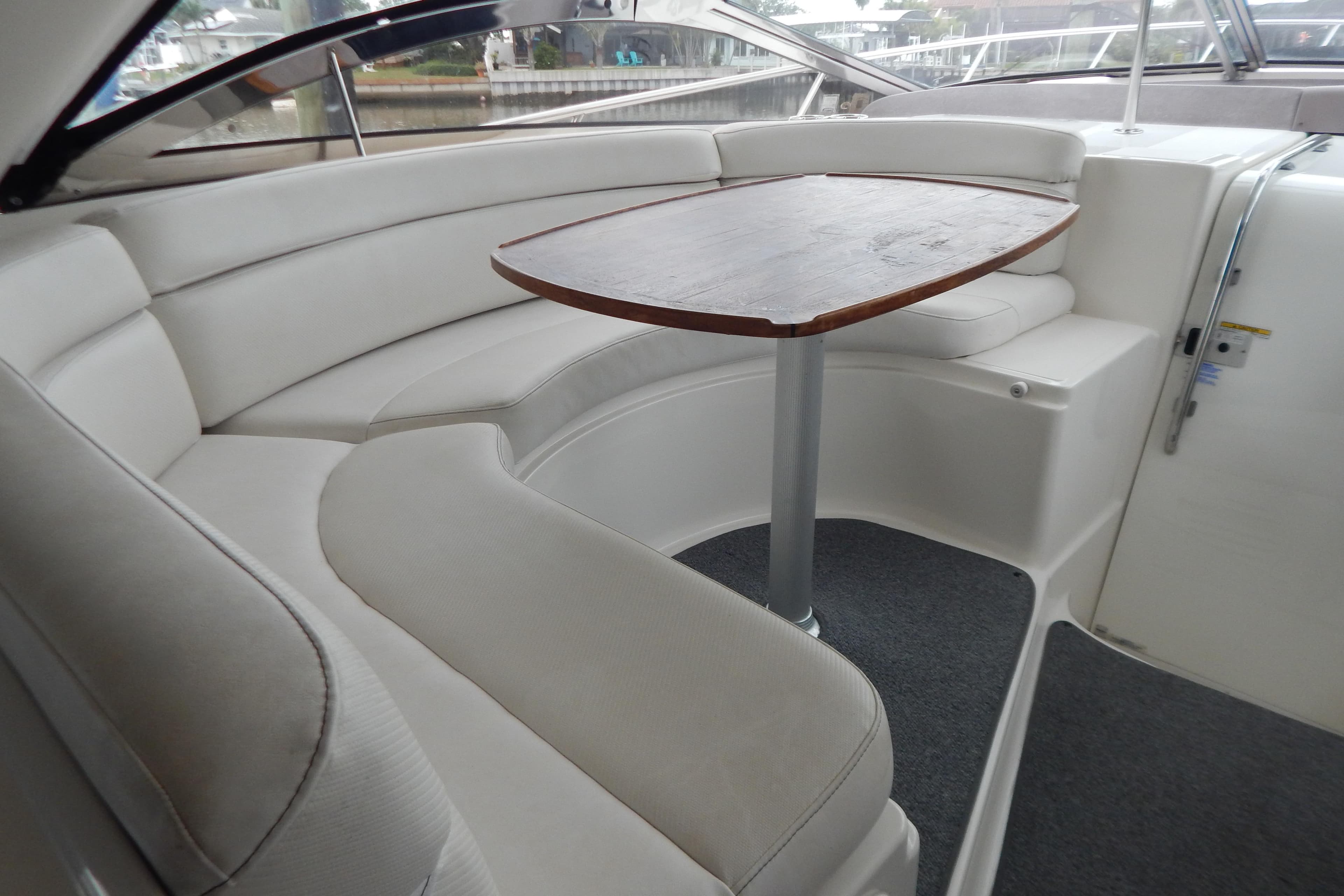 Luxurious interior seating of 2004 Regal Commodore 4260 yacht with wooden table.