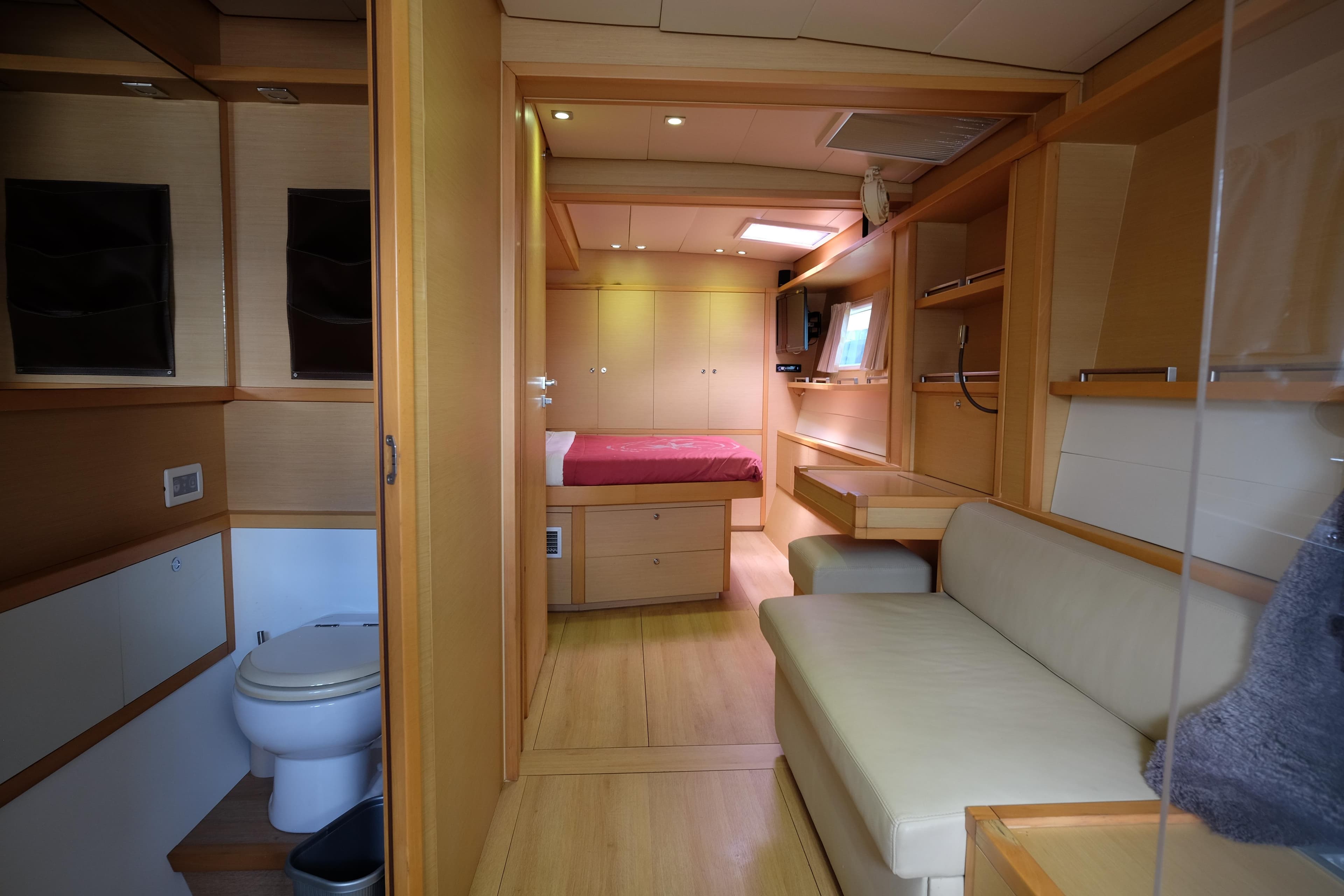 Luxurious interior of 2011 Lagoon 620 yacht featuring bedroom, seating, and bathroom.