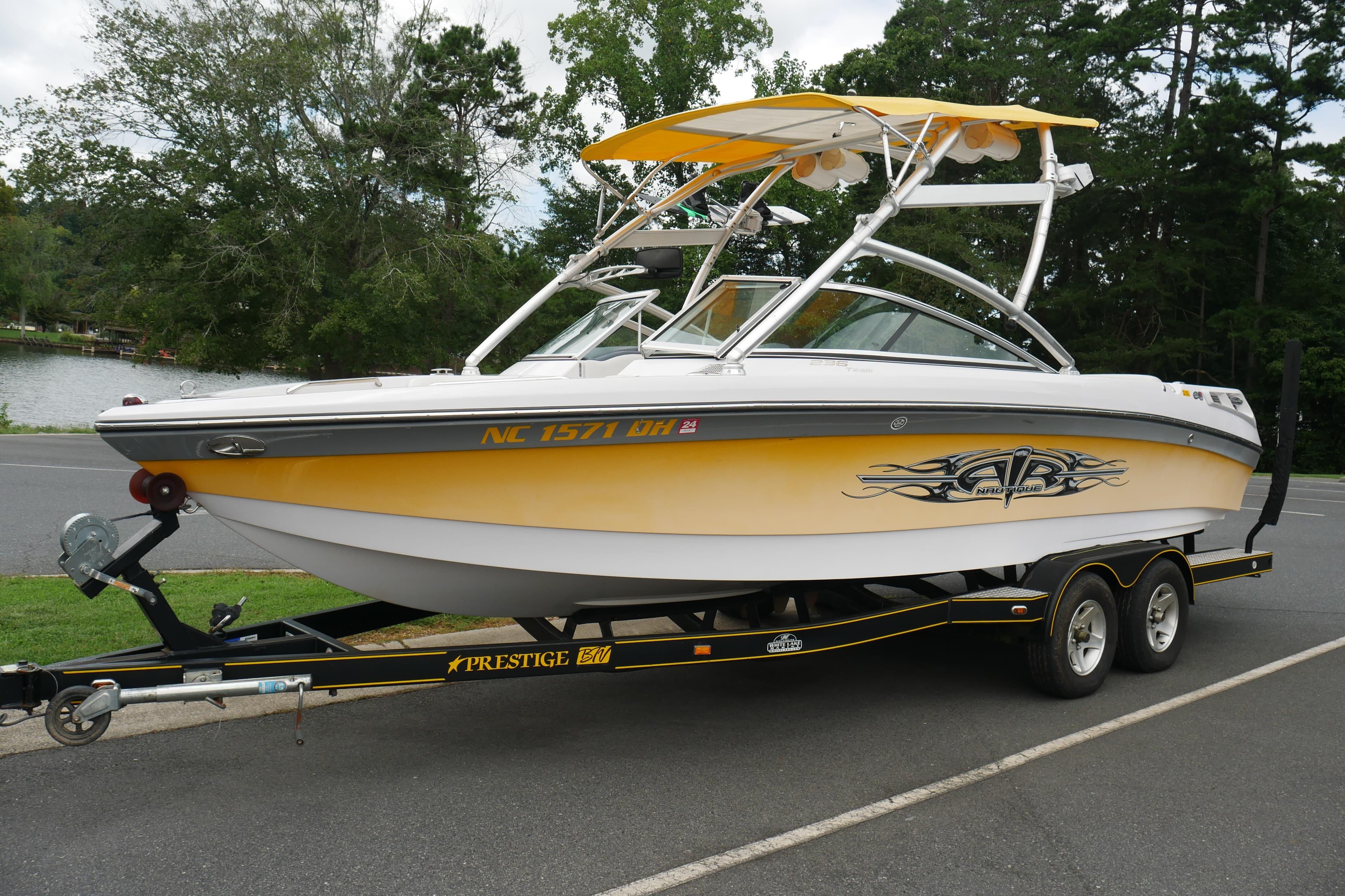 2007 Correct Craft 236 Team Edition boat on trailer, parked near a lake.