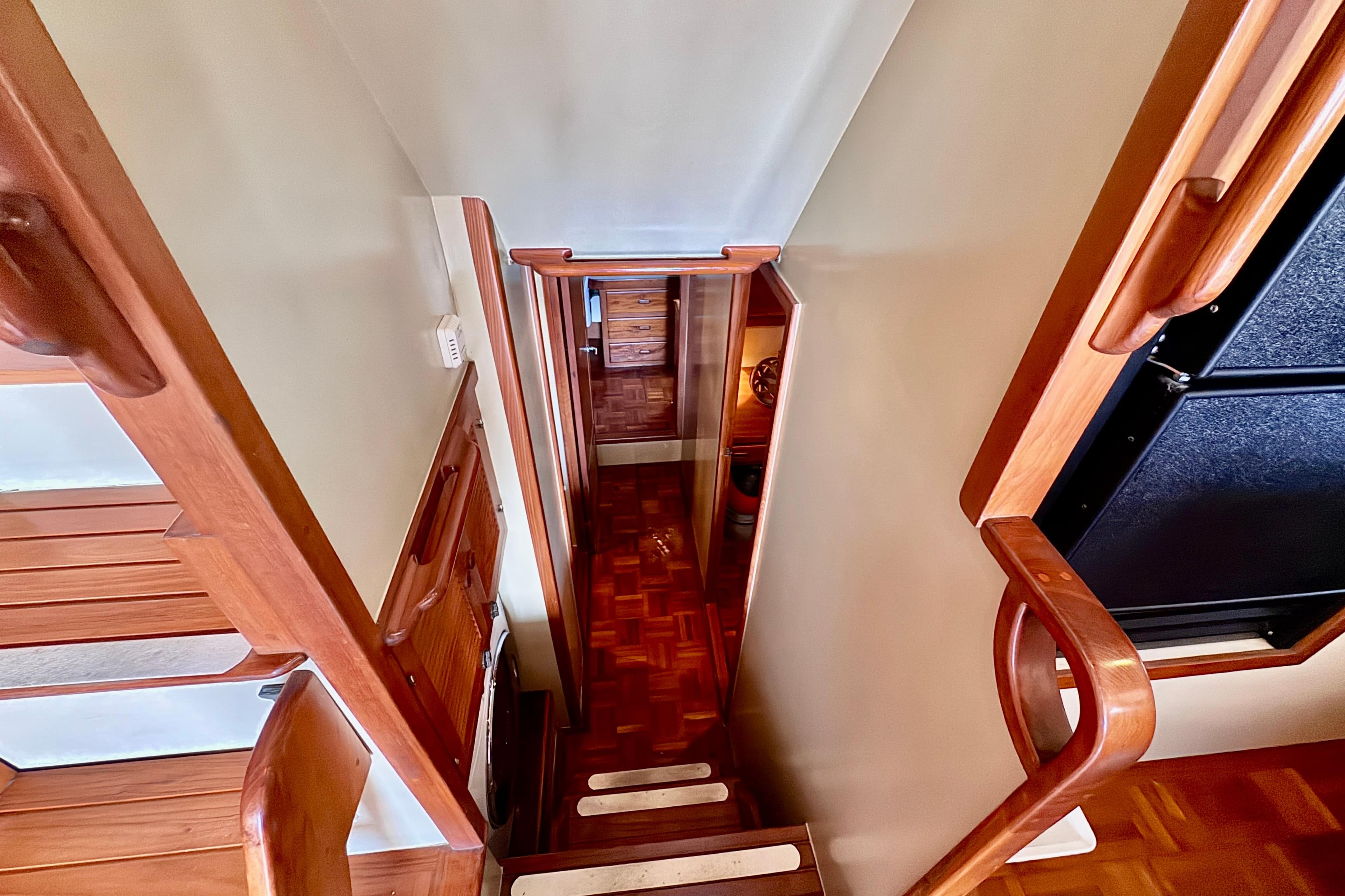 Staircase inside 1986 Kadey-Krogen 42 yacht with wooden handrails and flooring.