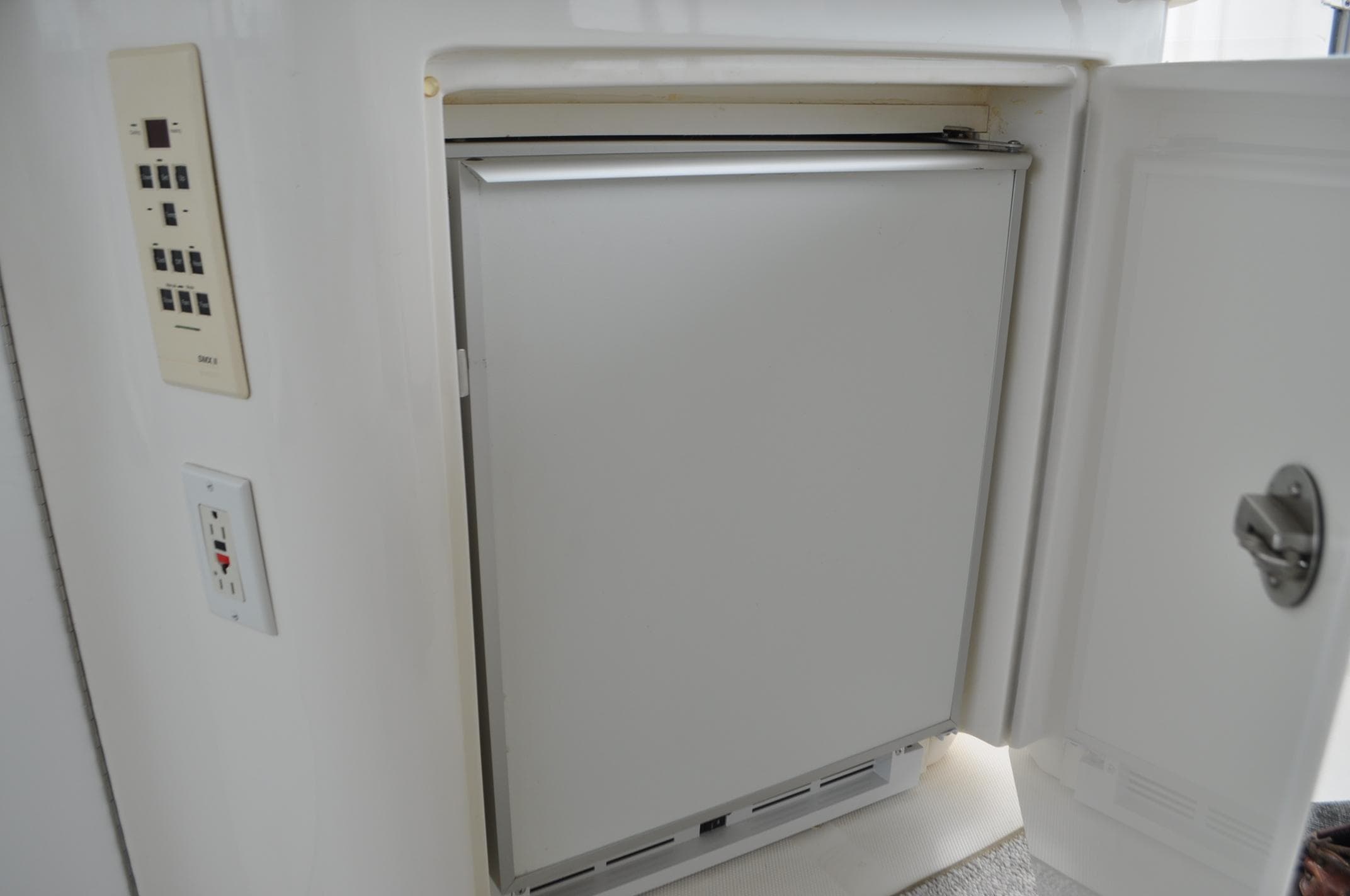 Built-in refrigerator on 2002 Sea Ray 480 Motor Yacht, with open door and control panel.