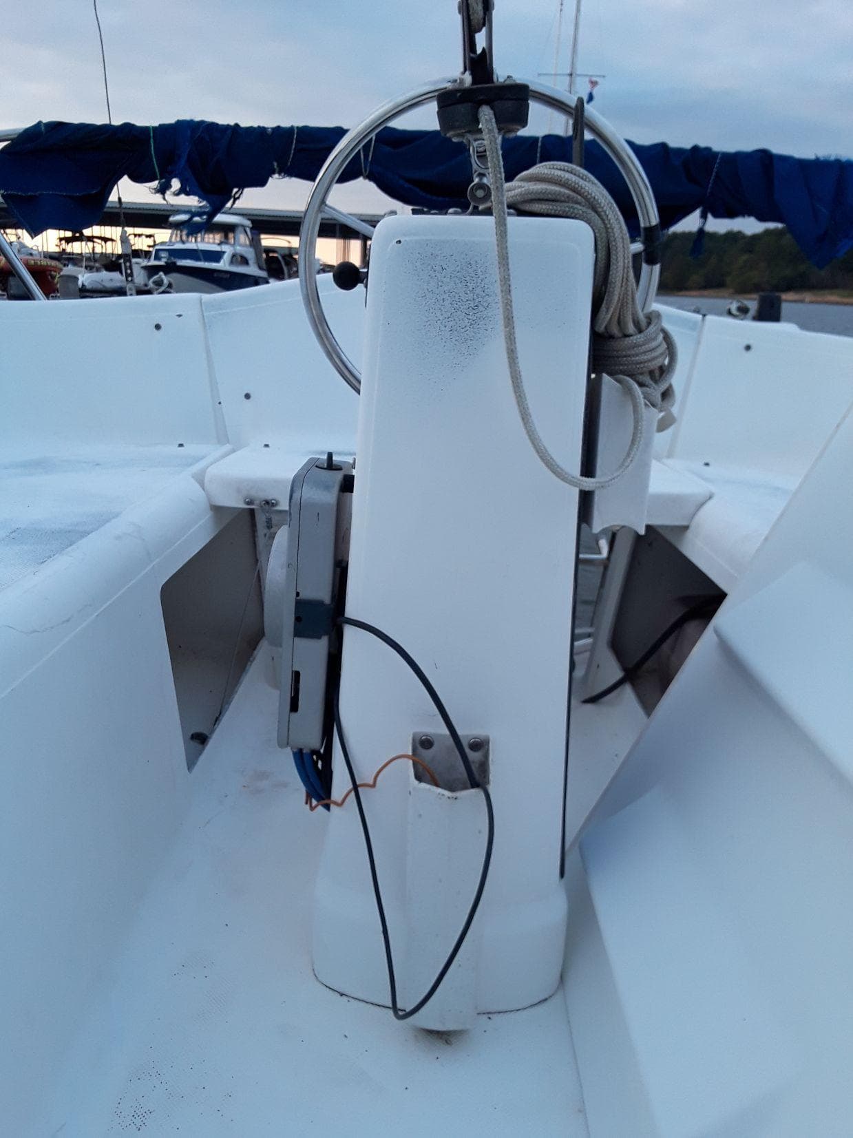 1996 MacGregor 26 "X" sailboat cockpit with steering wheel and ropes.