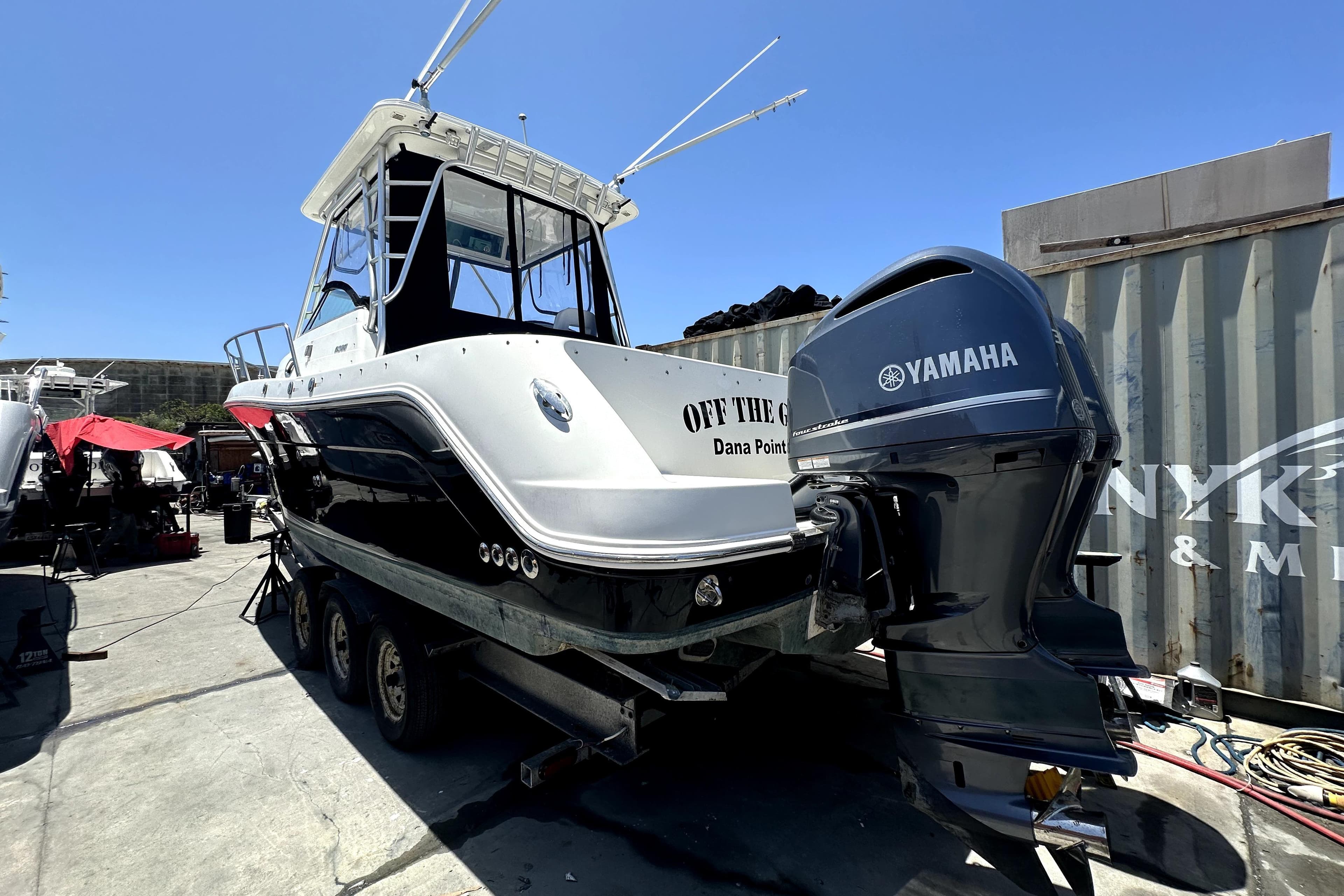 2007 Robalo R305 Walkaround boat with Yamaha engine on trailer, docked at marina.