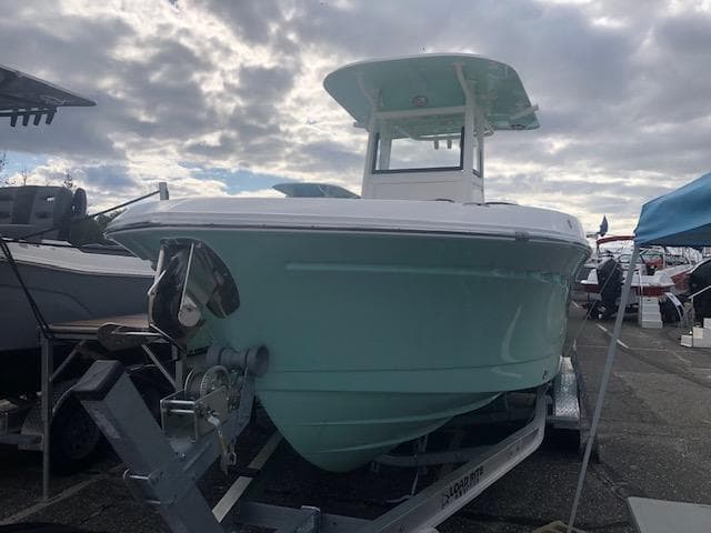 2023 NauticStar 242L Offshore boat on trailer under cloudy sky.
