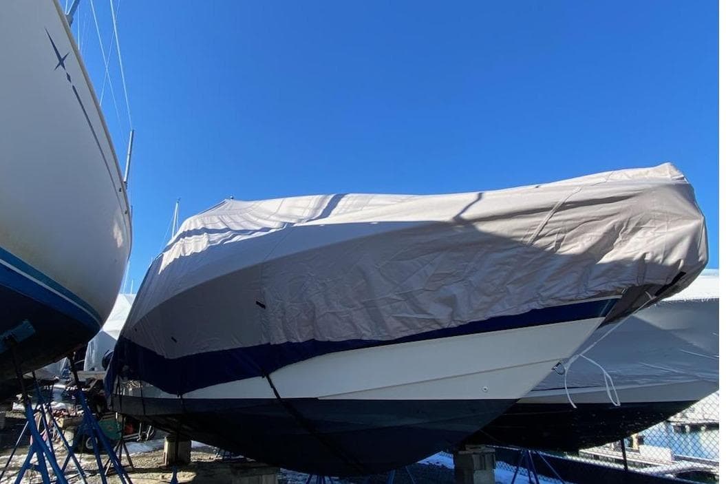 2016 Formula 310 Bowrider boat covered and stored outdoors under a clear blue sky.