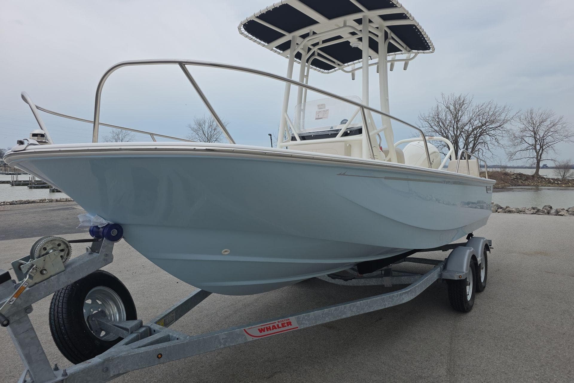 2026 Boston Whaler 190 Montauk boat on trailer, parked near a waterfront.