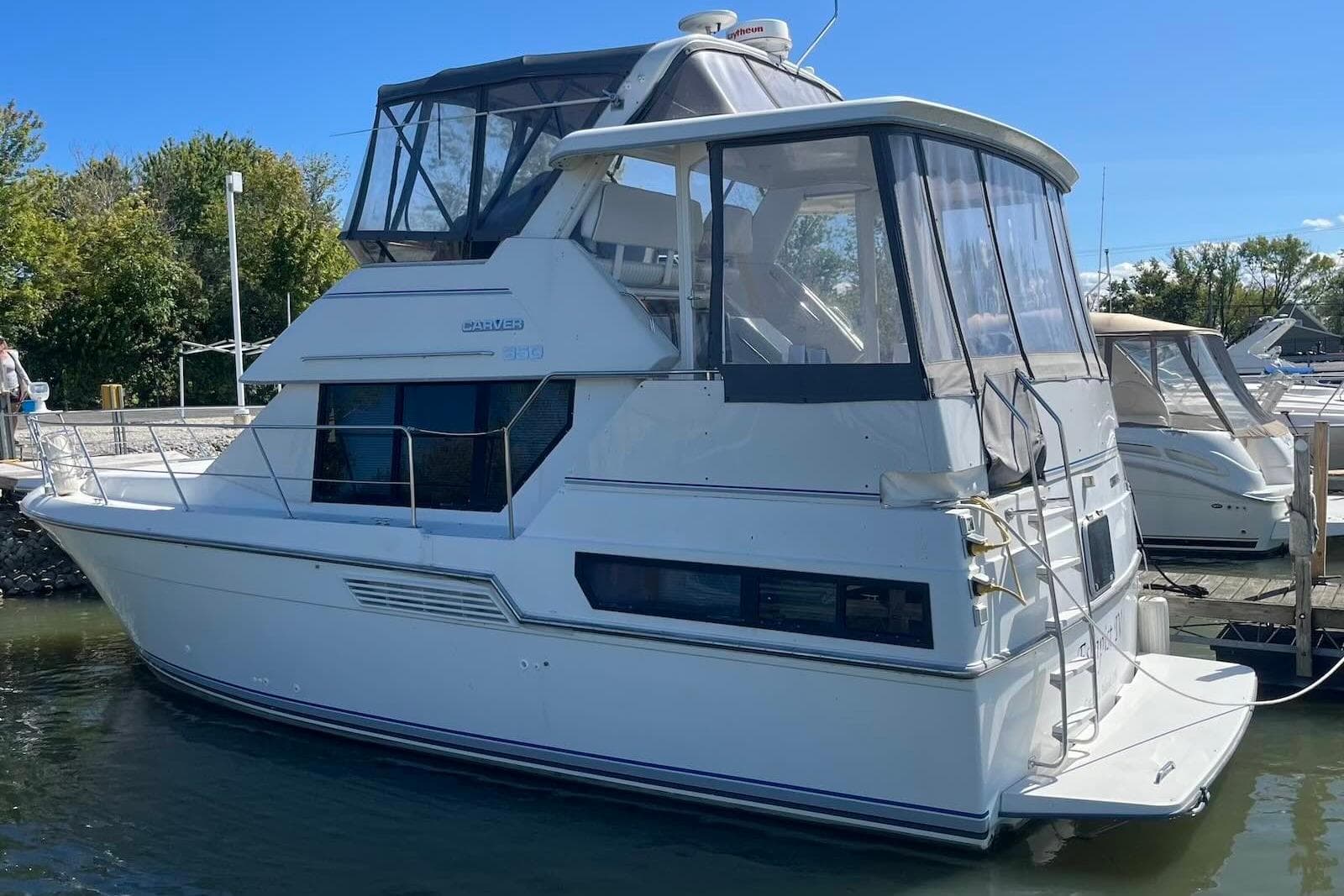 1993 Carver 350 Aft Cabin Motor Yacht docked at marina under clear blue sky.