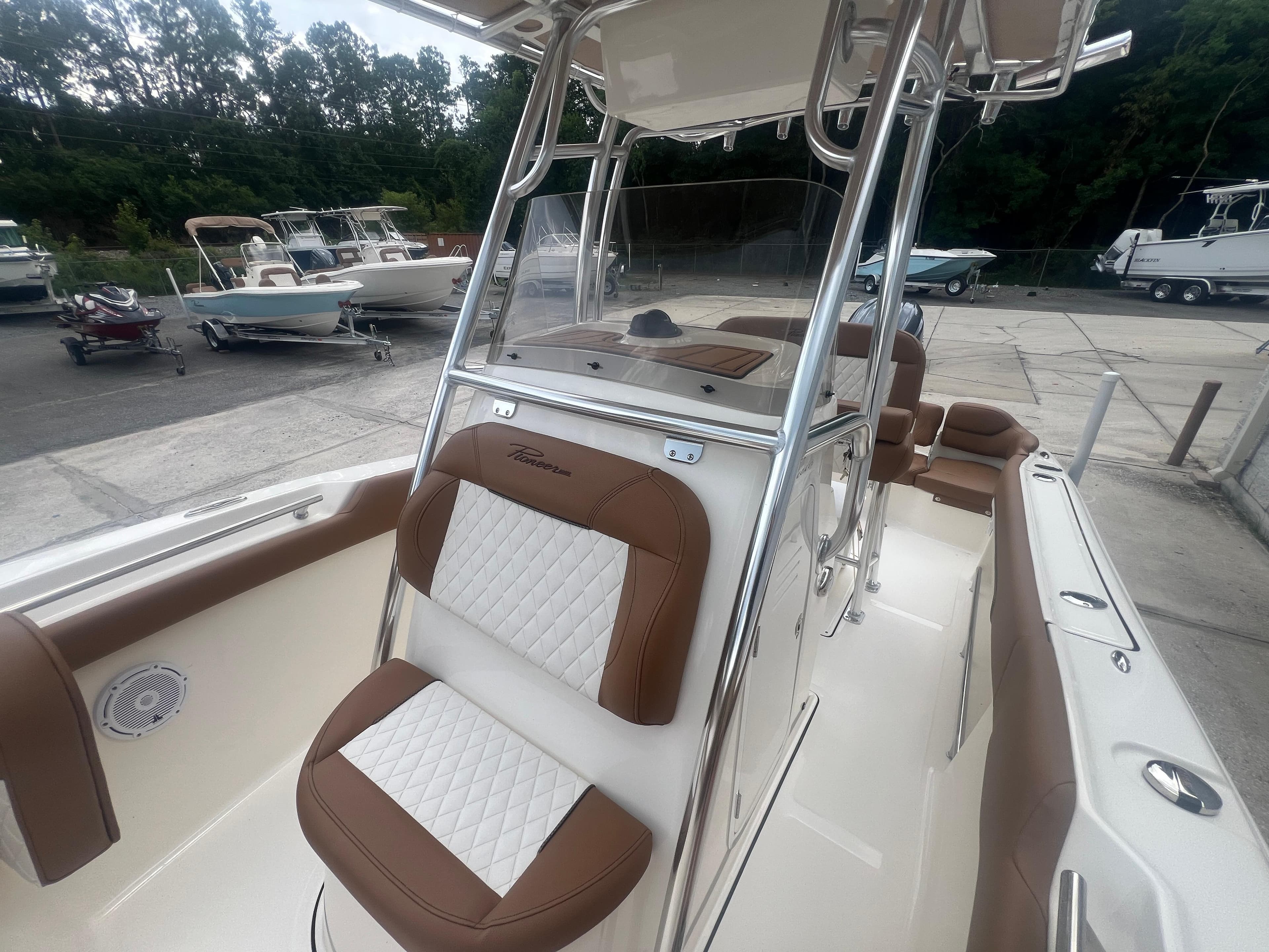 2026 Pioneer 202 Islander boat with brown and white seating, docked outdoors.