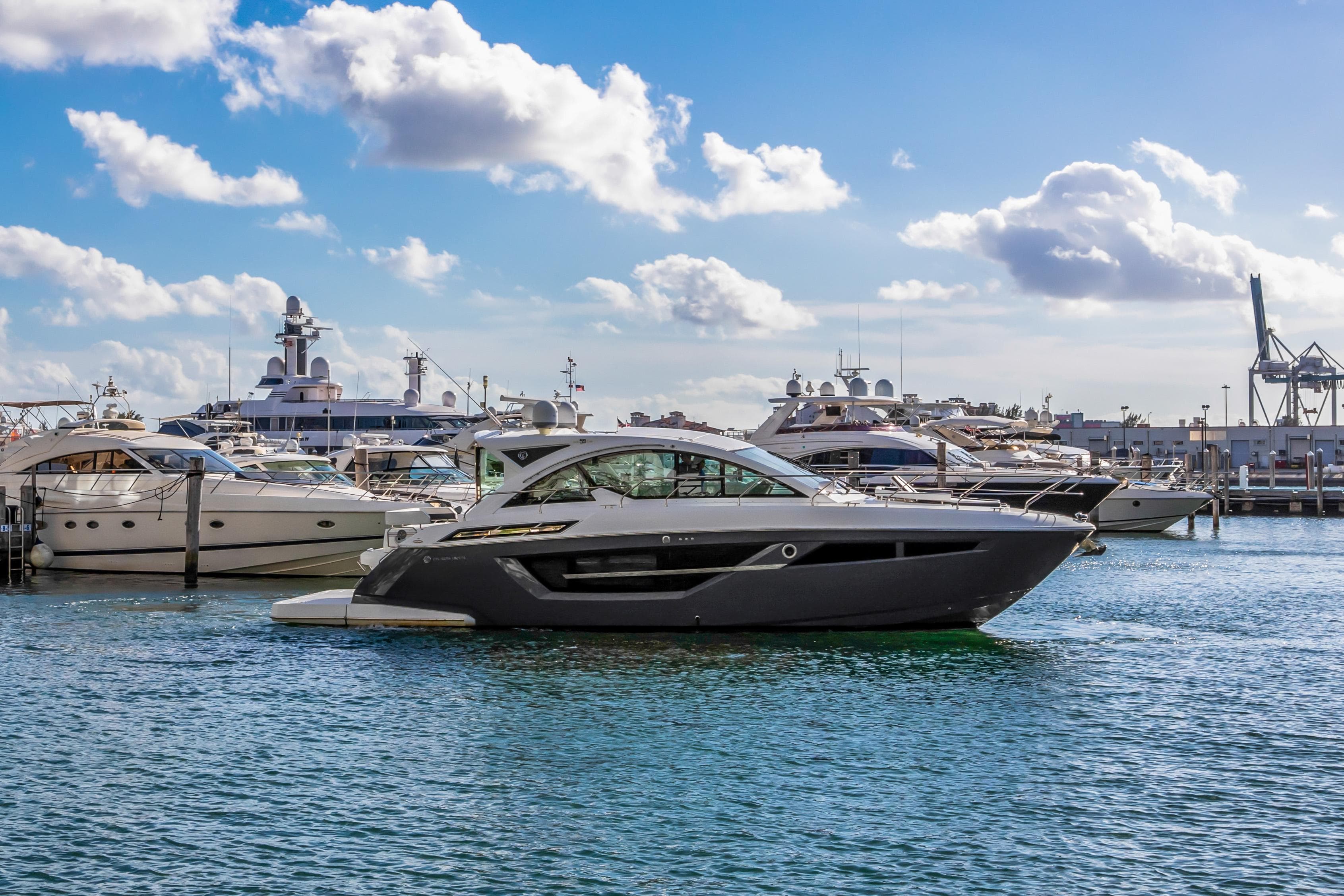 2019 Cruisers 50 Cantius yacht docked in a marina with other luxury boats.