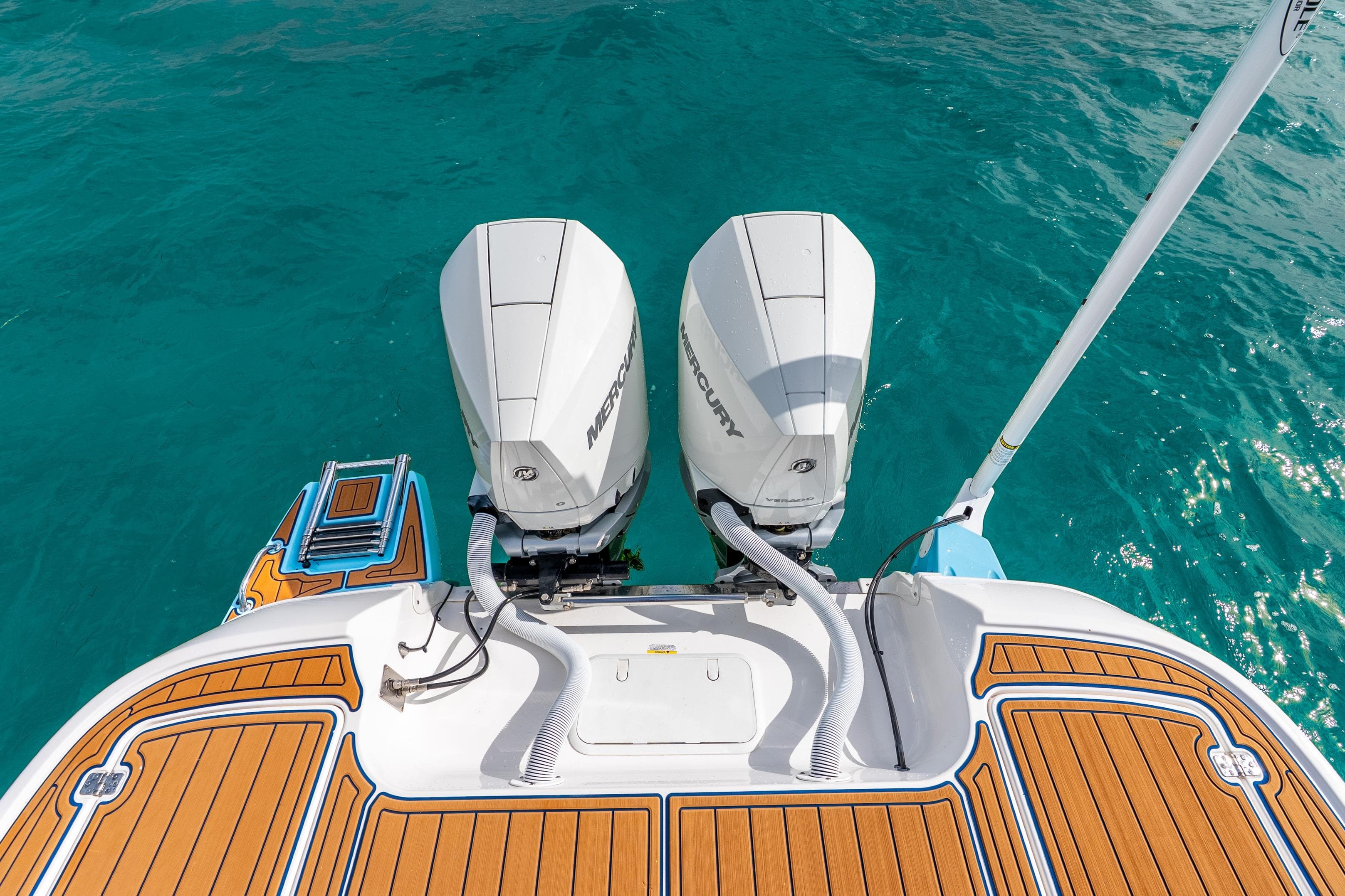 2024 Caymas 281 HB boat with dual Mercury engines on turquoise water.