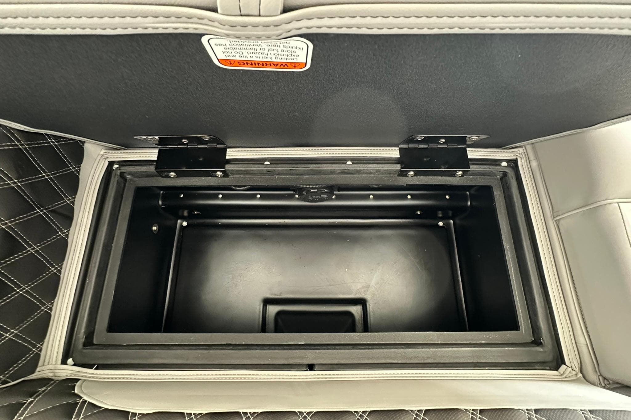 Open storage compartment in 2026 Ranger Reata 223FC boat with quilted upholstery.