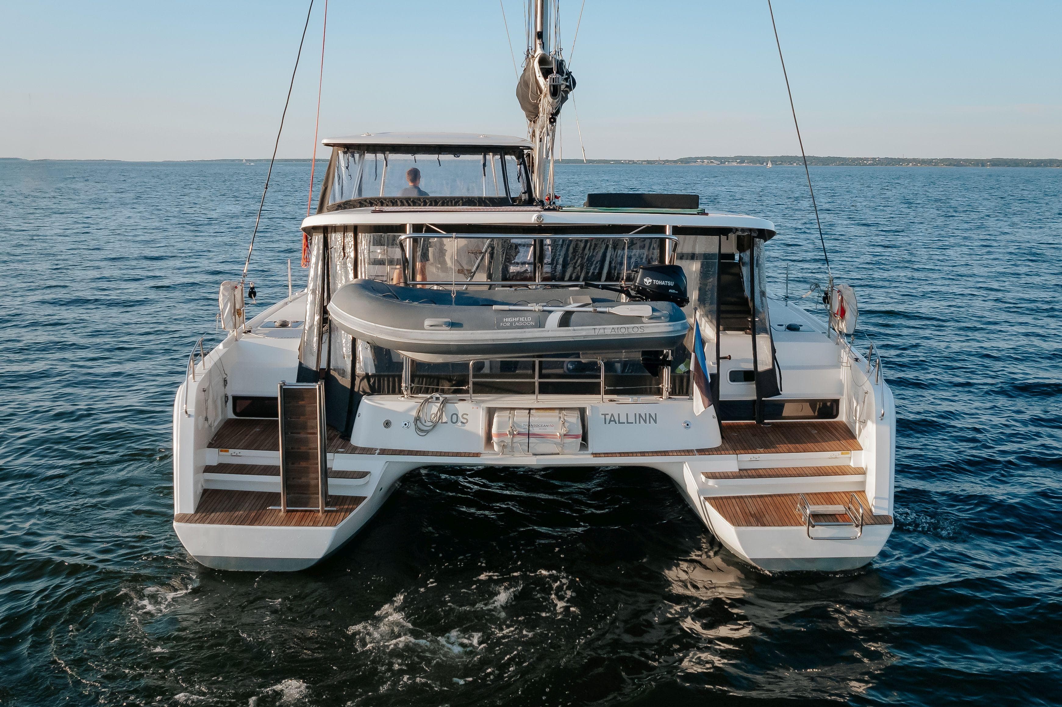 2019 Lagoon 42 catamaran sailing on open water, rear view.