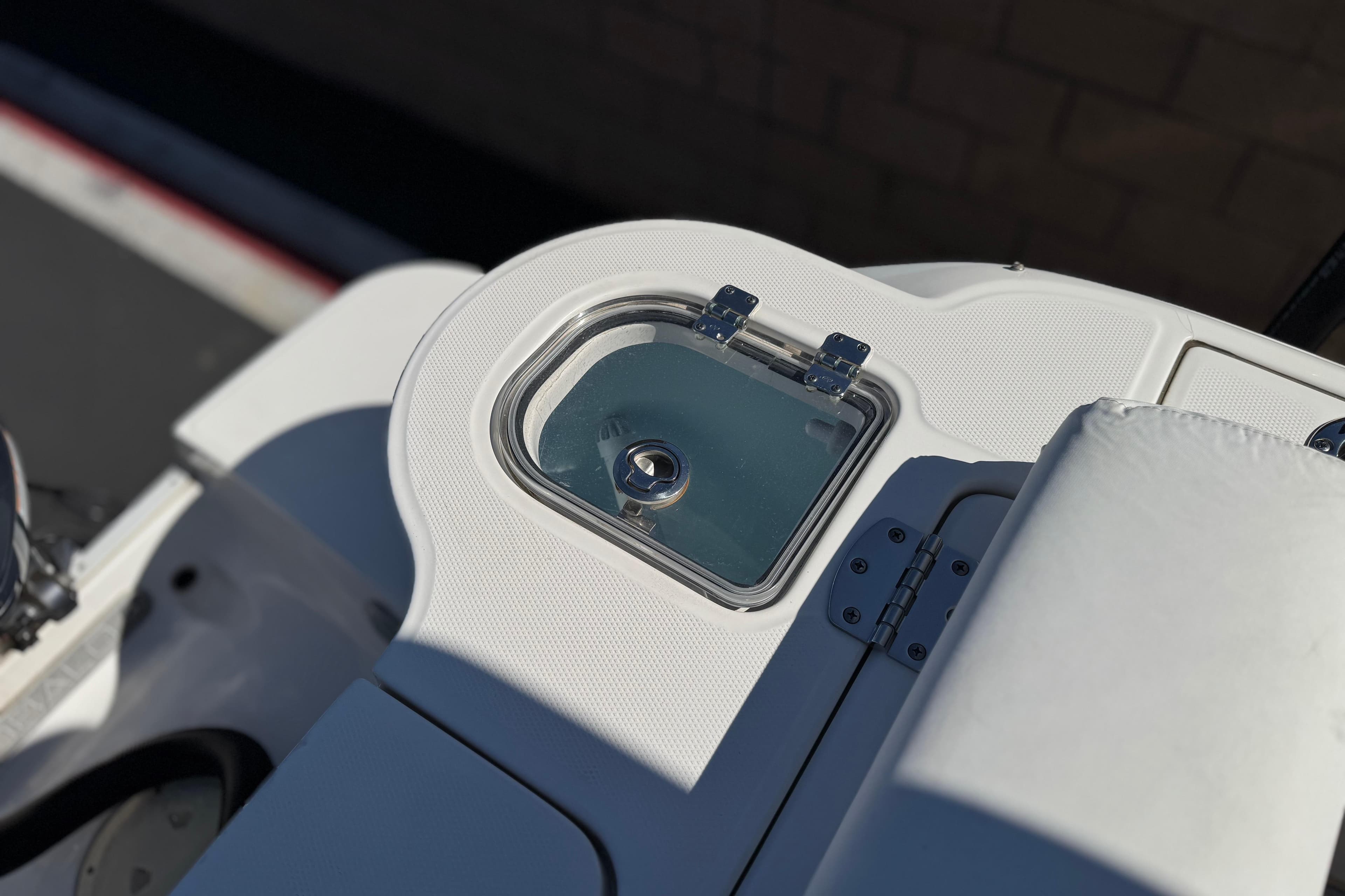 2022 Robalo R247 Dual Console boat detail with storage compartment and cushioned seating.