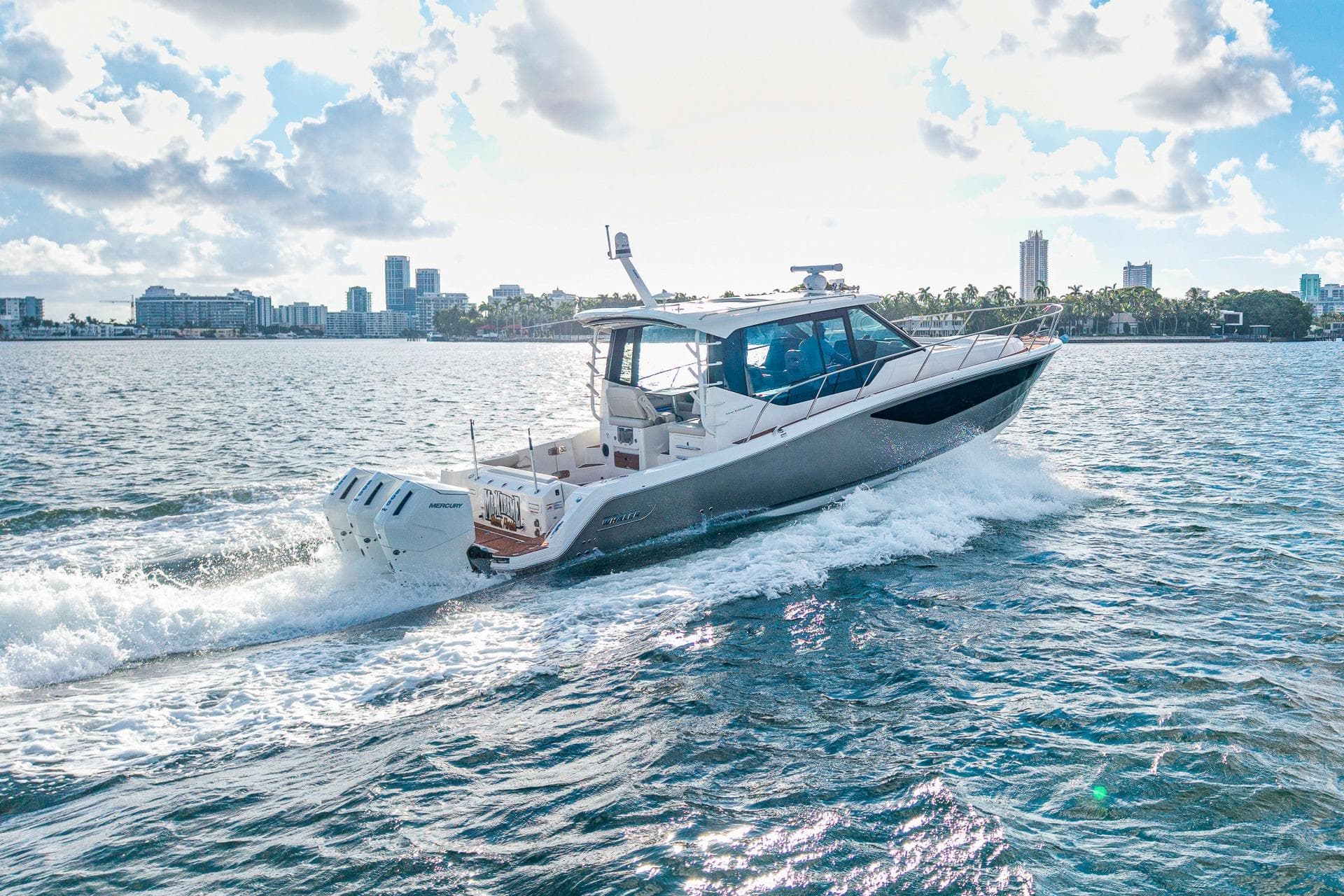2024 Boston Whaler 405 Conquest cruising on a sunny day near city skyline.