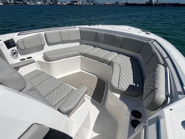 Luxurious seating area on 2023 Pursuit S358 boat with quilted cushions, ocean view.