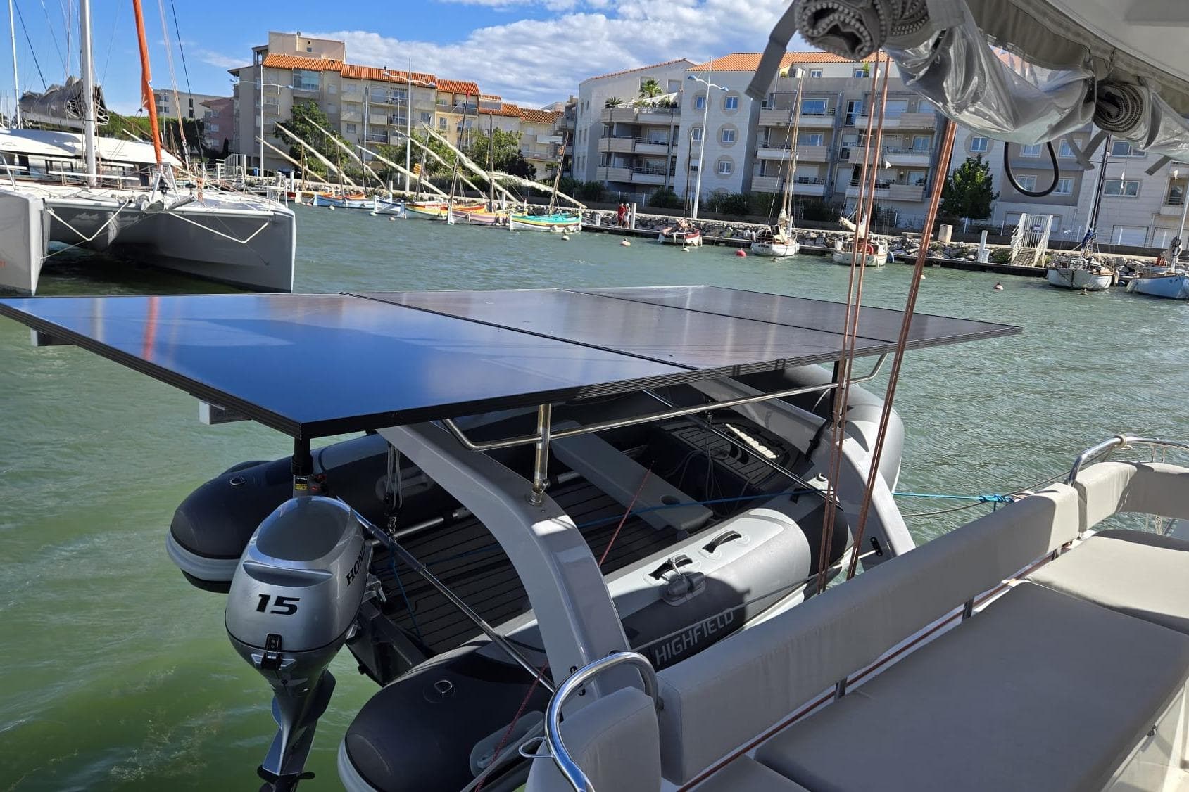 Excess 14 catamaran with solar panels and outboard motor in marina, 2025 model.
