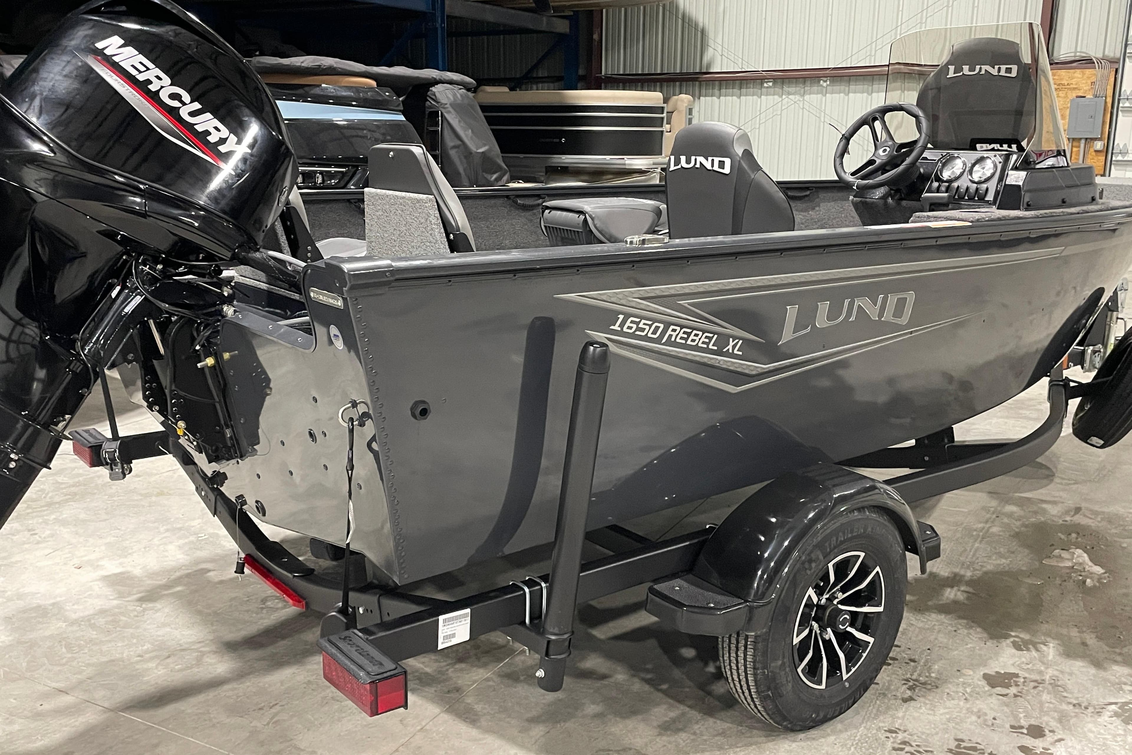 2026 Lund 1650 Rebel XL SS boat with Mercury engine in a garage setting.