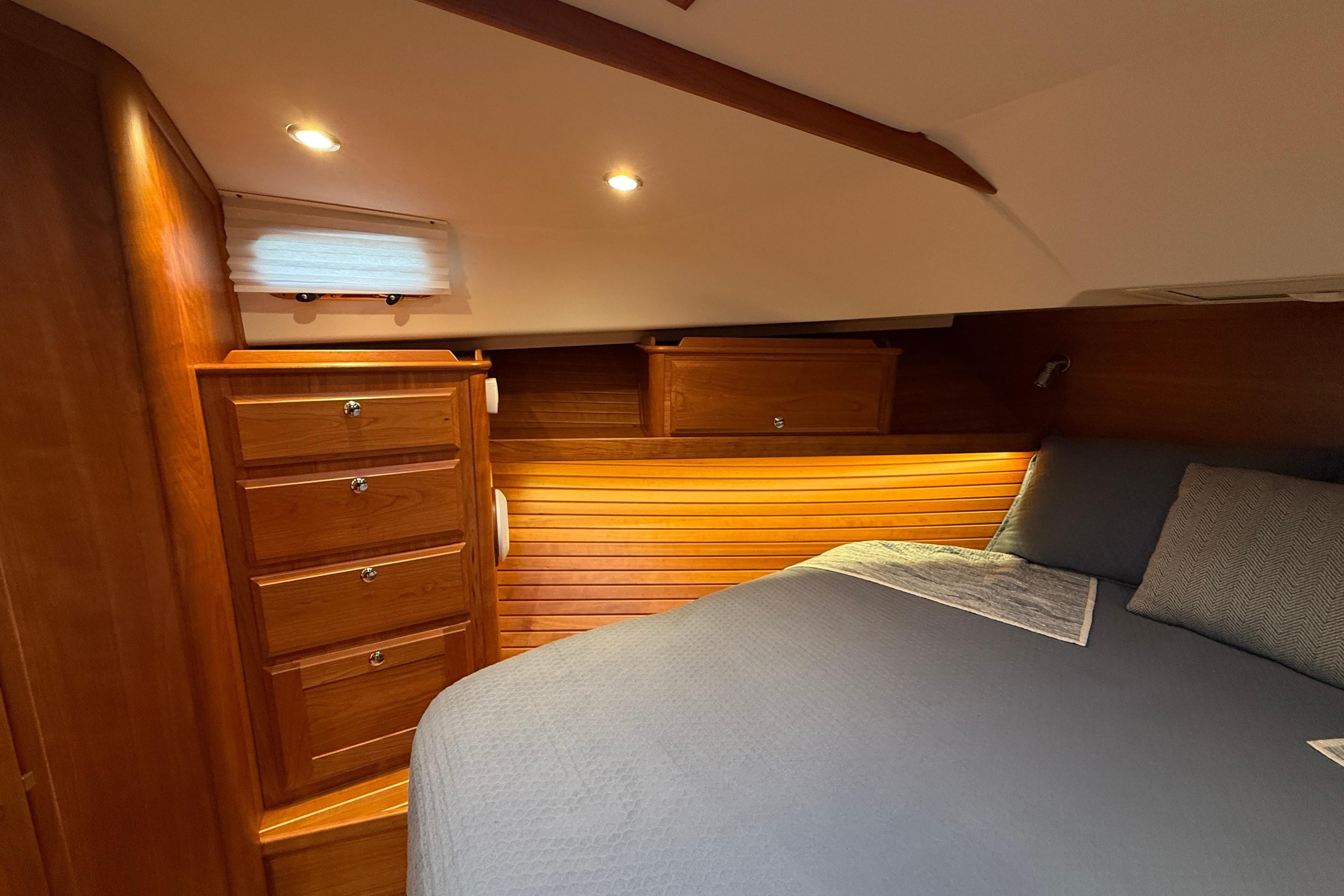 Luxurious 2023 Sabre 43 Salon Express cabin with elegant wood finish and cozy bedding.