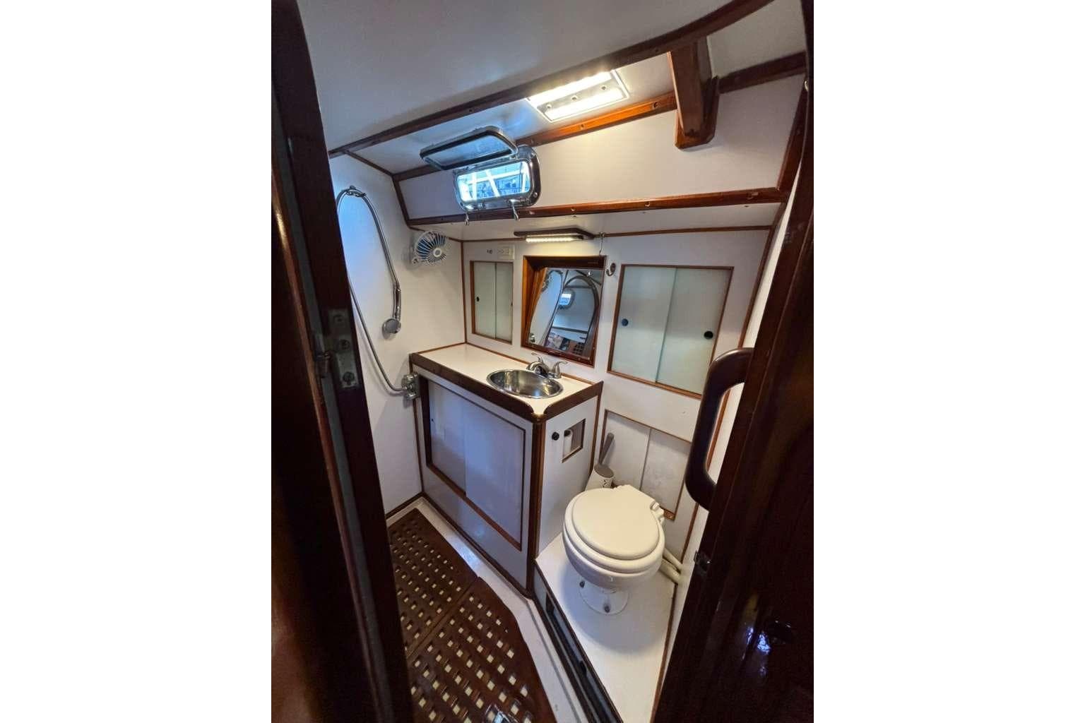 Compact bathroom in 1982 Steven Custom Stevens 47 yacht with sink, toilet, and shower.