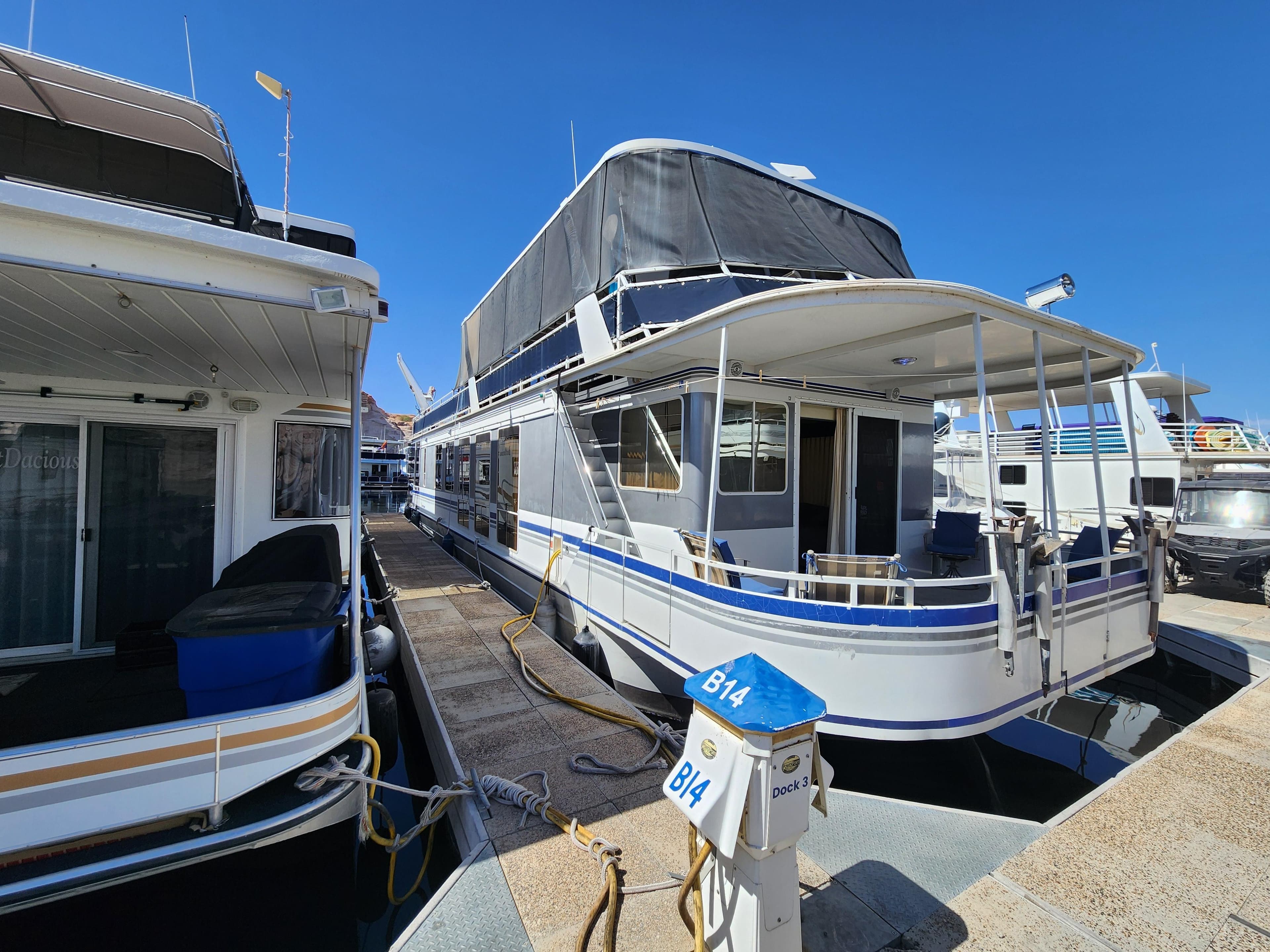 2004 Skipperliner Inn Conspicuous Share houseboat docked at marina under clear blue sky.
