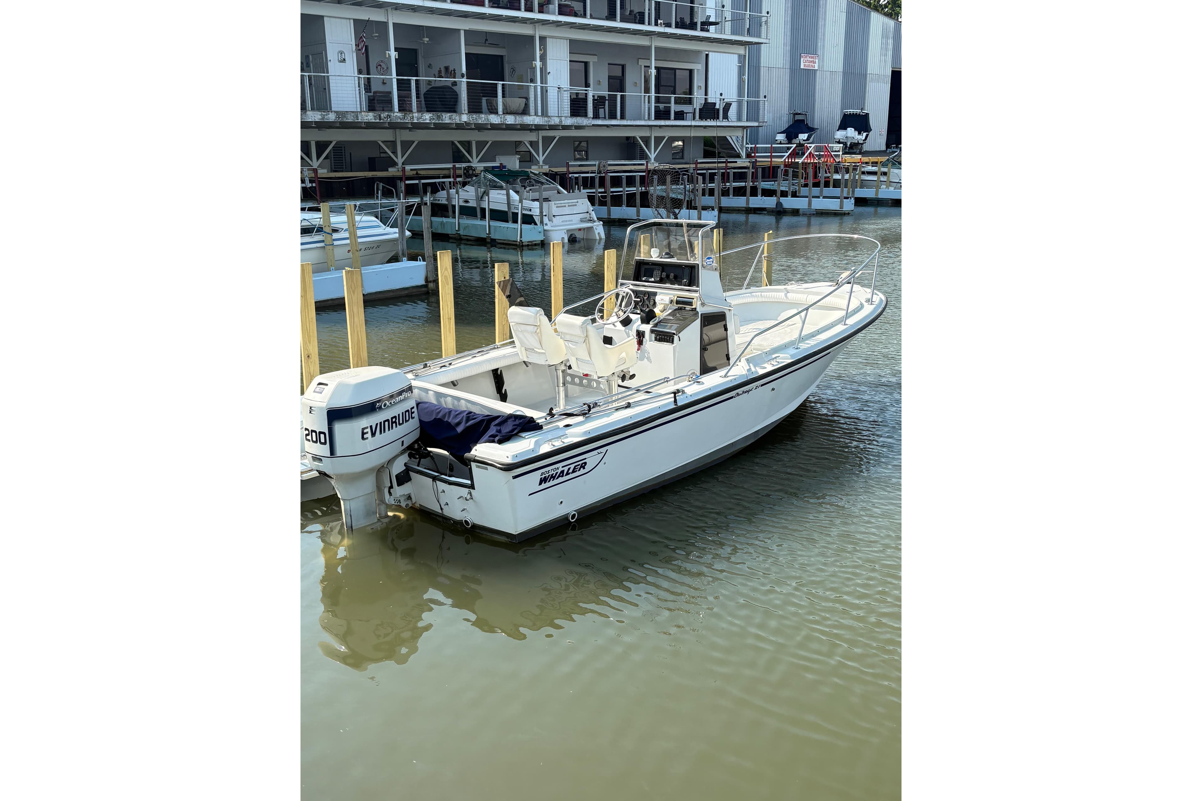 1993 Boston Whaler 21 Outrage boat docked with Evinrude motor in marina.